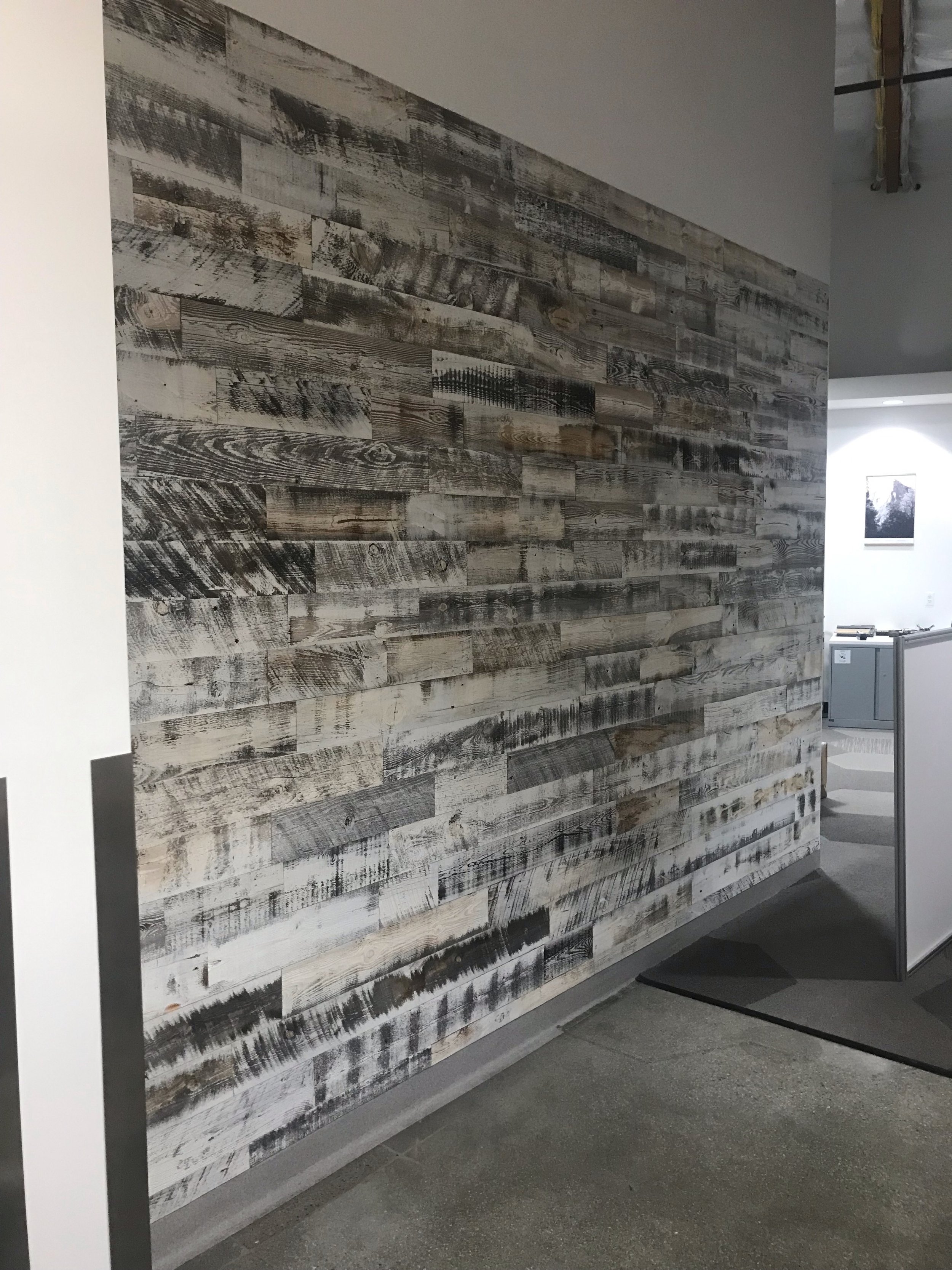 Textured reclaimed wood accent wall installed in commercial hallway for natural character