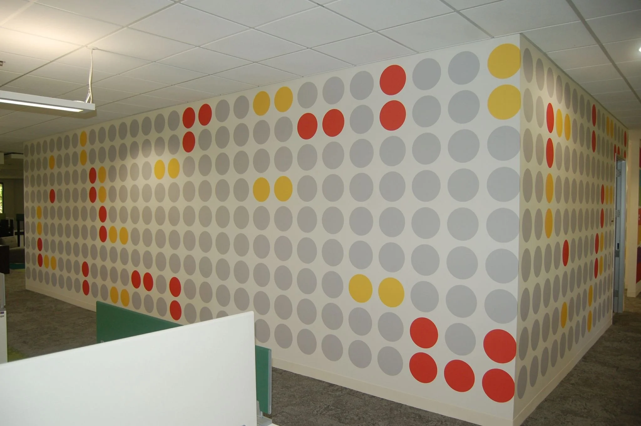 Patterned dot wallcovering used to enhance a contemporary office workspace with custom environmental graphics.