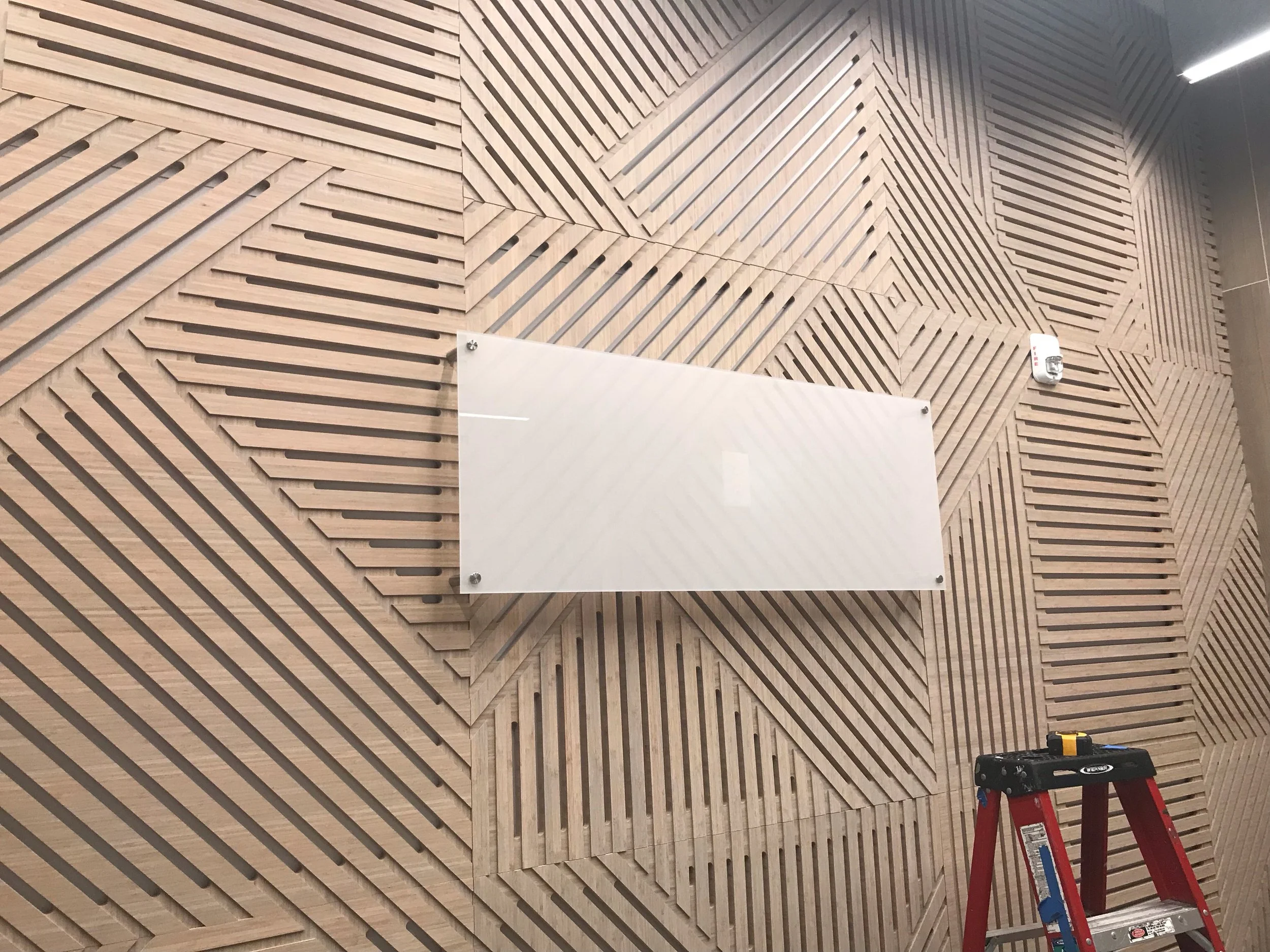 Geometric wood slat feature wall adding texture and dimension to commercial office space
