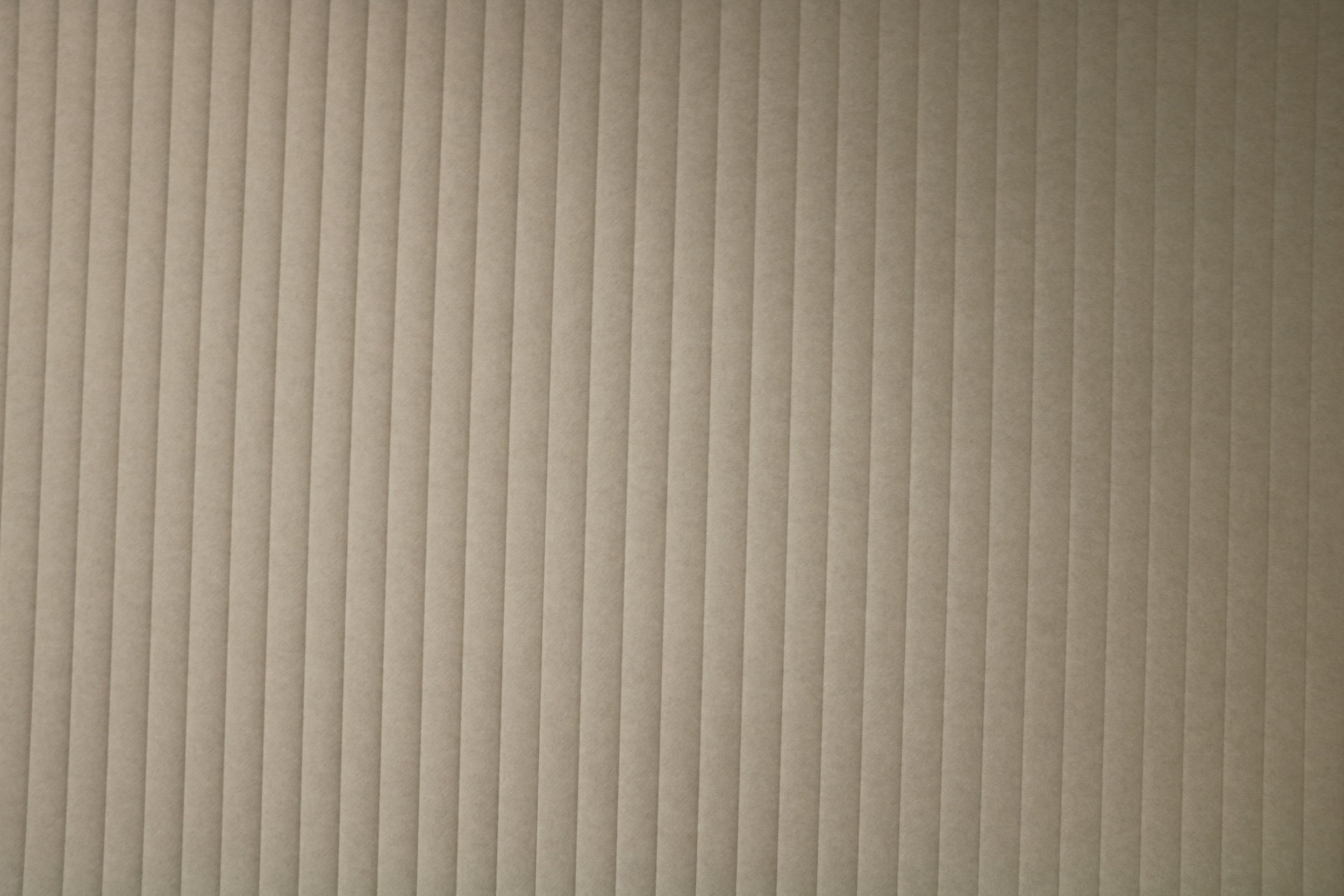 Close-up of Acoufelt Almond vertical PET acoustic wall panels showing linear texture for commercial interior sound control.