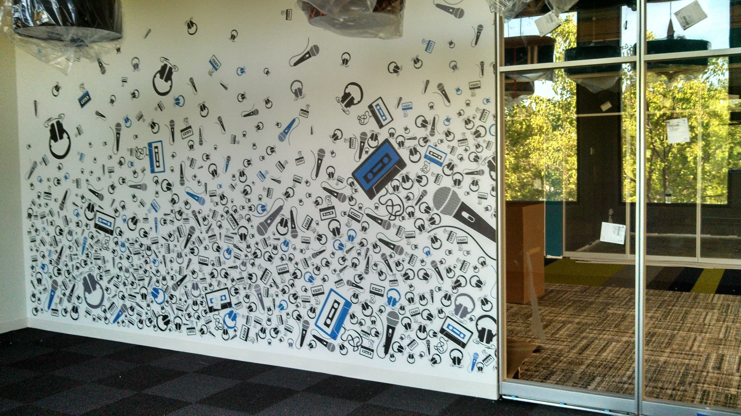 Custom scattered graphic pattern wallcovering adding subtle movement and branding to an office entry area.