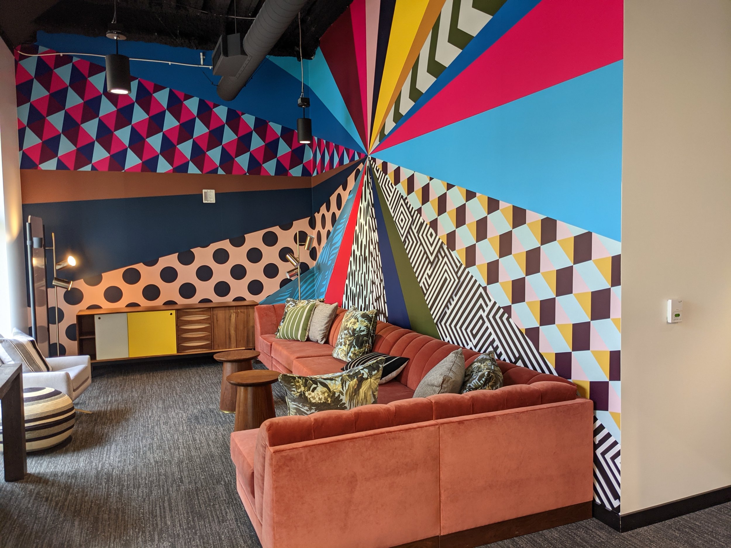 Bold geometric and patterned feature wall with custom printed wallcoverings in a corporate lounge, creating a branded, high-impact interior environment installed by JP Digital.