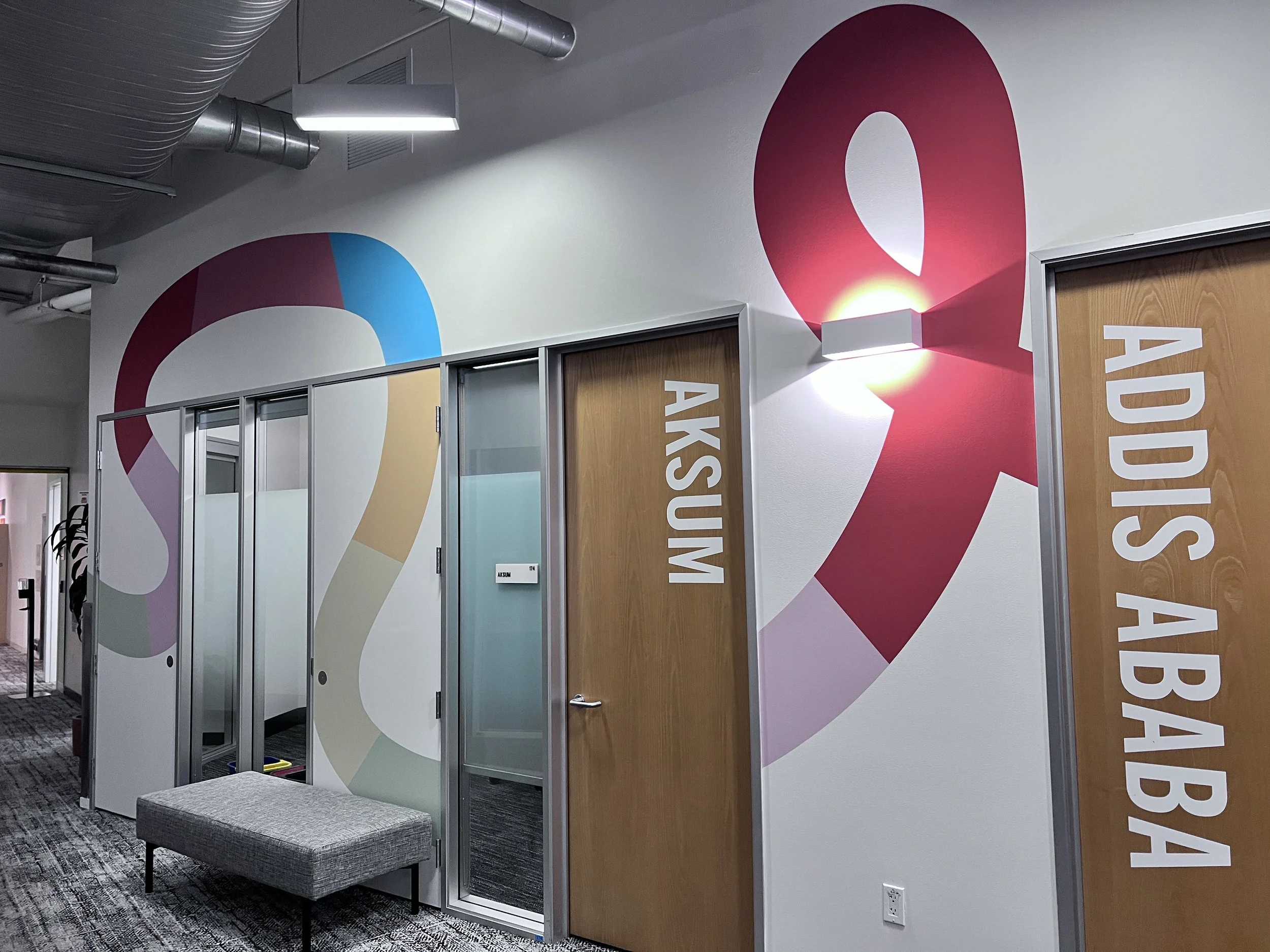 Colorful environmental wall graphics integrated around doors in the Amphitheatre interior.