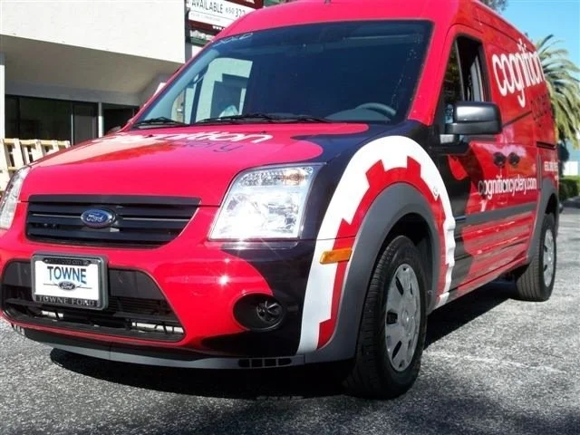 Full wrap on compact service vehicle with bold red graphics for high-visibility mobile advertising.