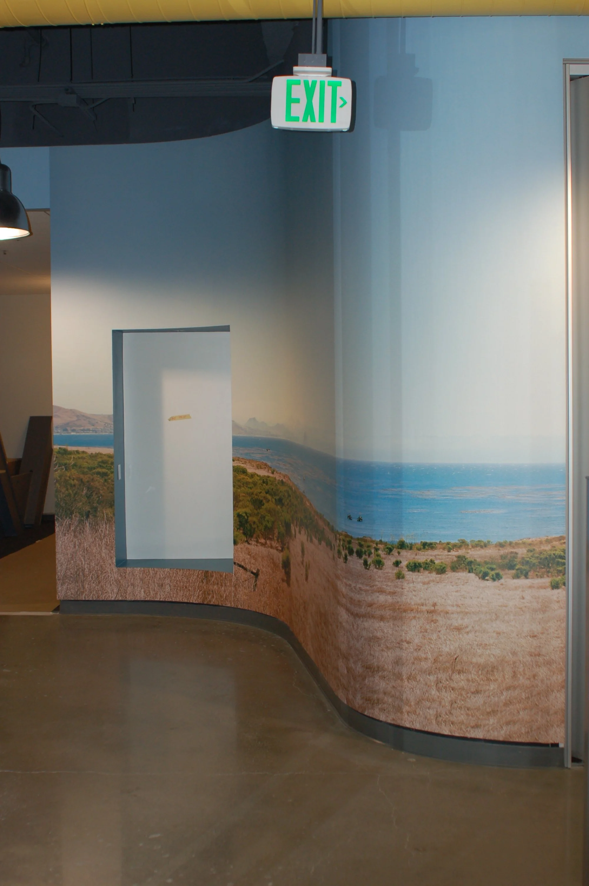 Custom world map environmental graphic with dimensional elements installed in a corporate corridor.