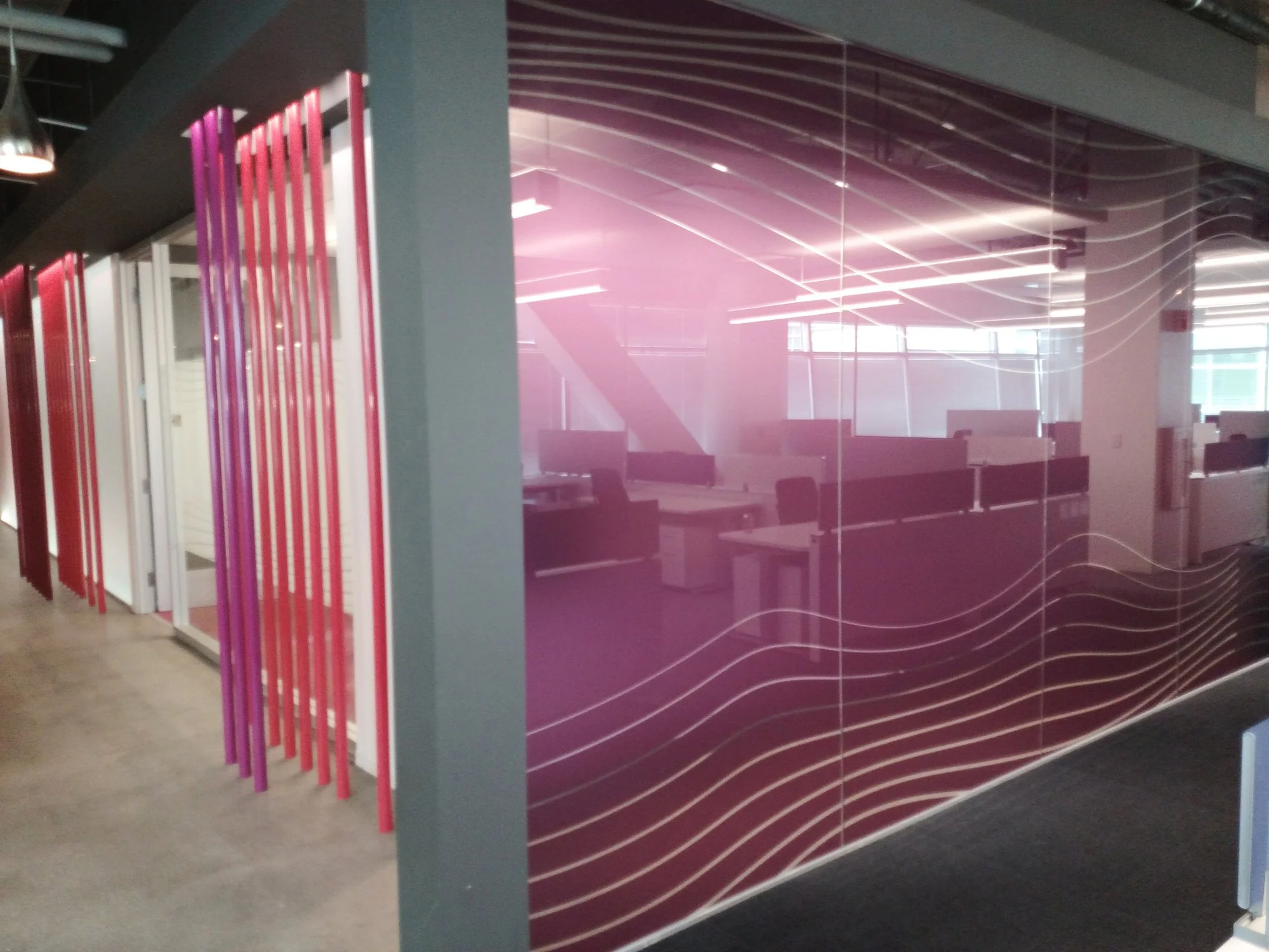 Decorative gradient window film with color tint applied to glass walls for privacy and bold architectural impact.