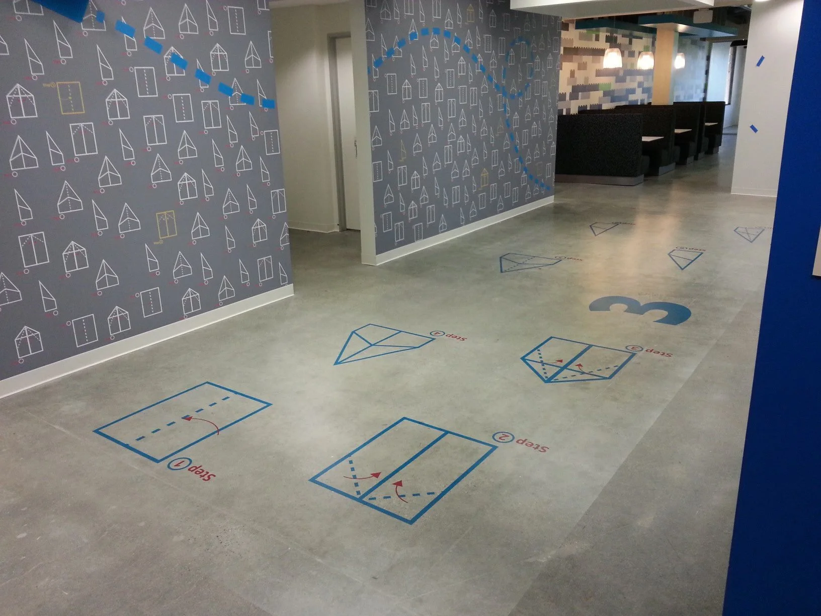 Custom commercial floor graphics with wayfinding and educational graphics installed in a high-traffic office corridor for navigation and visual engagement.