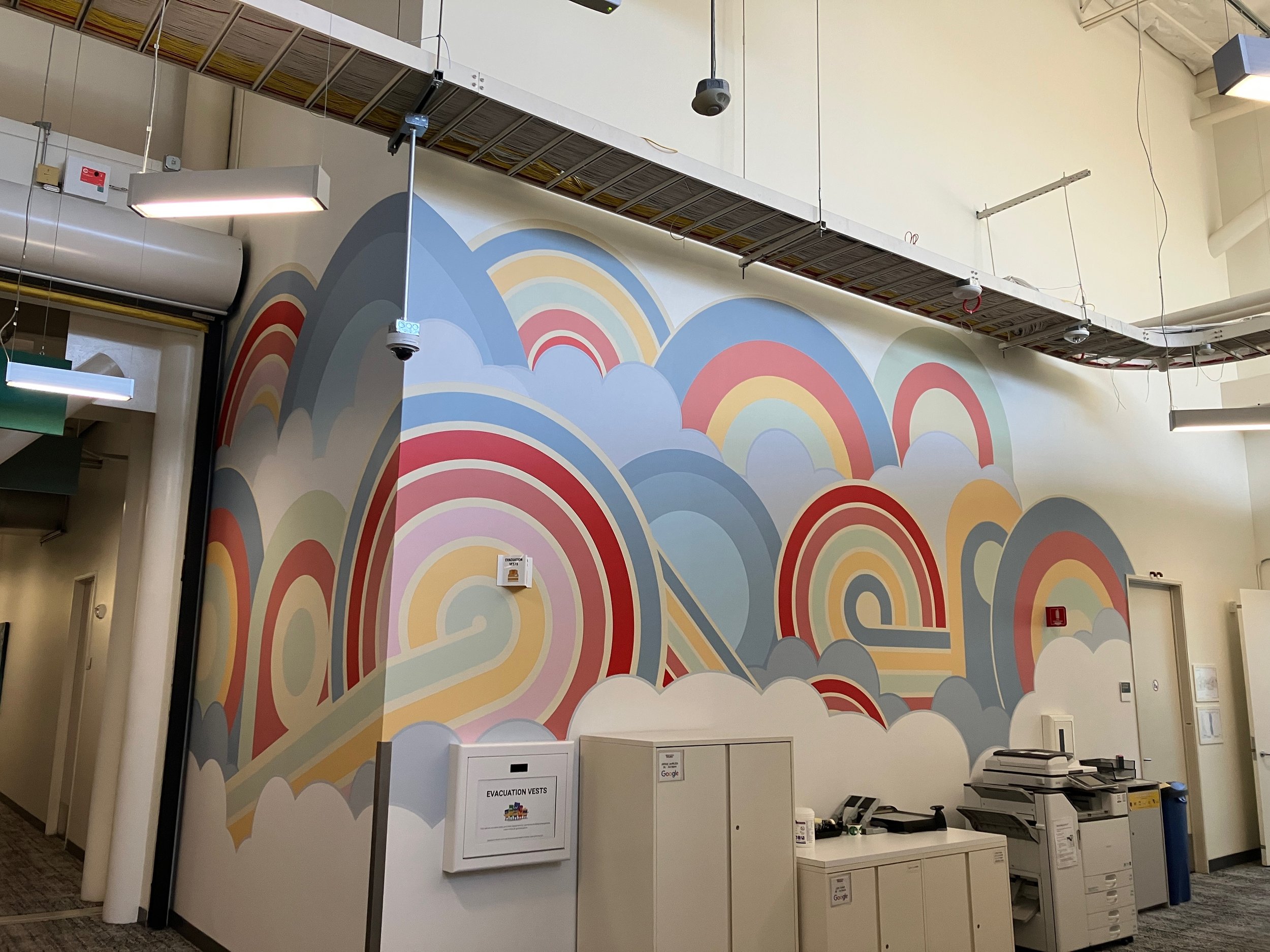 Completed custom environmental graphics integrated across staircase, platform, and wall to create a bold branded feature in corporate workspace