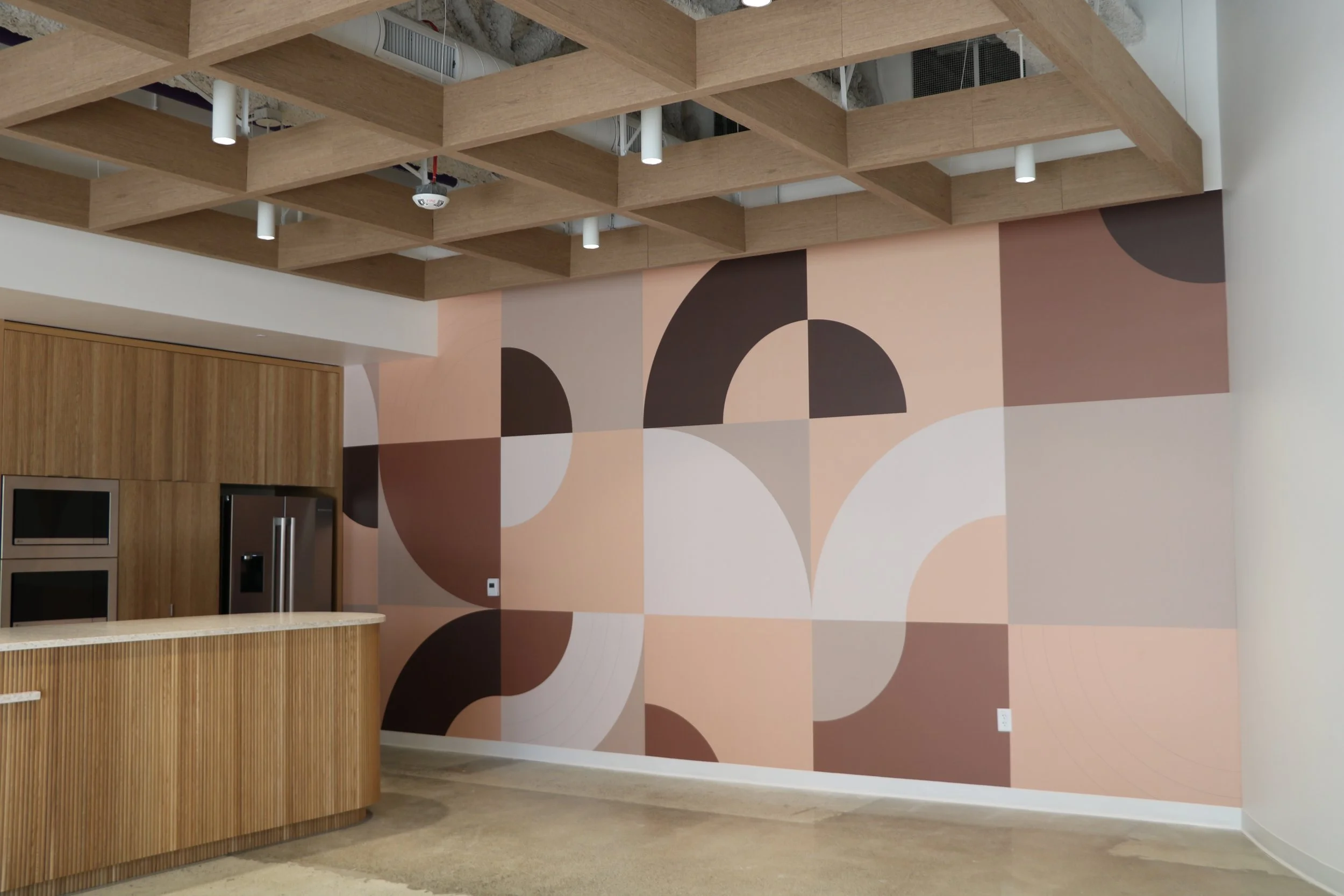 Custom wallcovering installed in commercial breakroom kitchen creating a durable and decorative feature wall for workplace interiors.