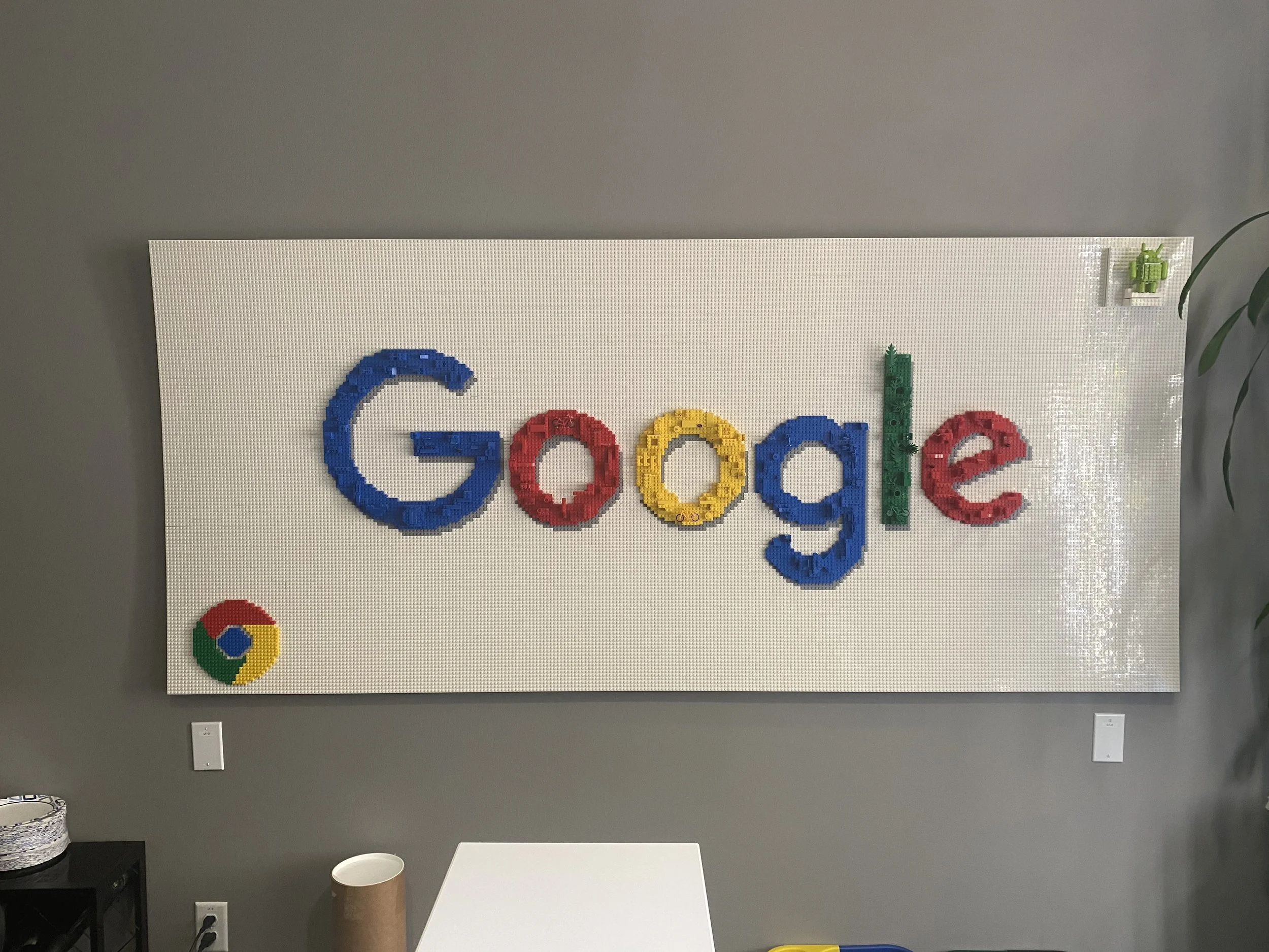 Dimensional Google logo feature wall installed to reinforce brand identity within workplace environment.
