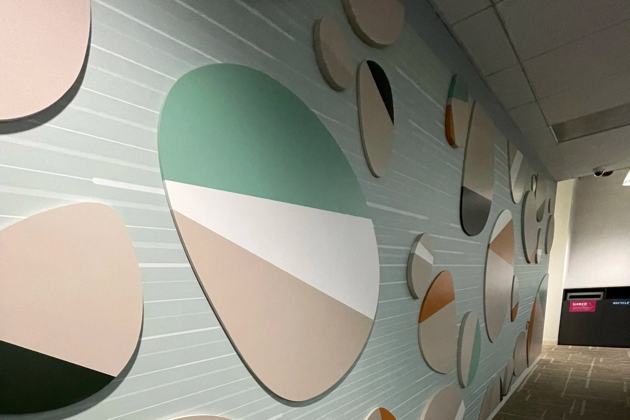 Perspective view of rock-themed wallcovering with dimensional layered stone elements installed in Amazon SJC3 corridor, fabricated and installed by JP Digital in Cupertino, California.