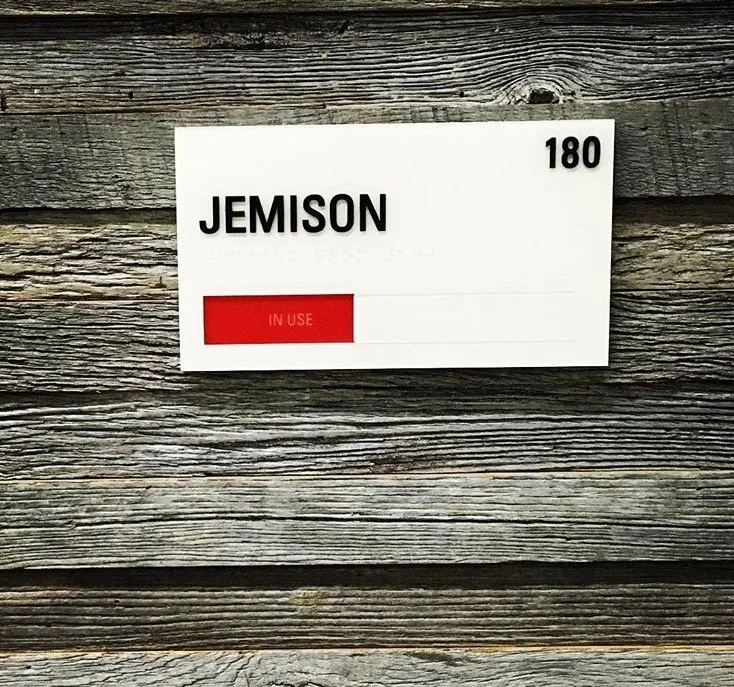 Custom room identification signage designed to support interior wayfinding in corporate environment