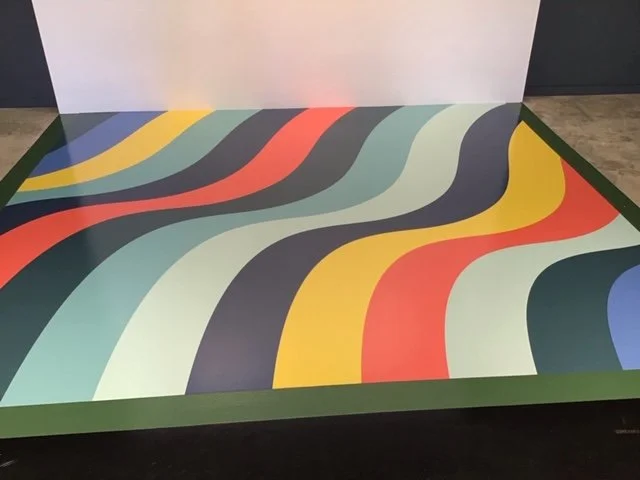Large-scale custom floor graphics with bold color patterns creating a branded feature in commercial space
