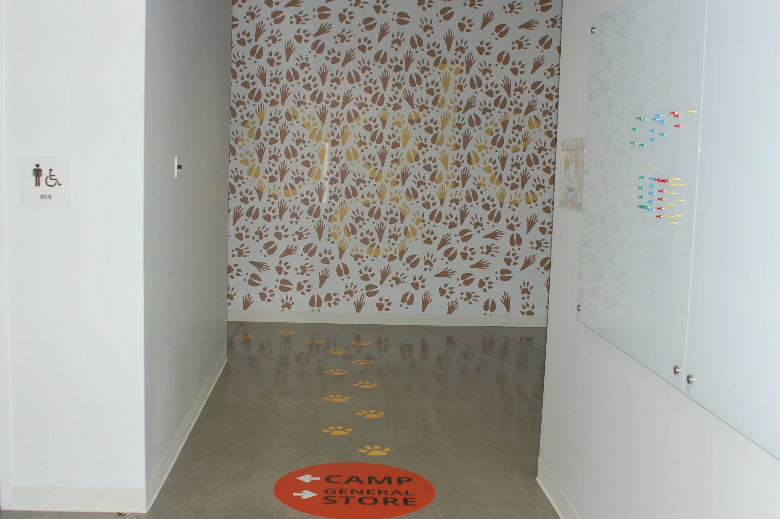 Branded floor graphics with footprint path guiding visitors through retail environment