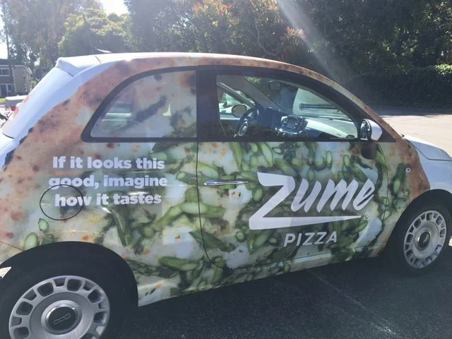 Partial vehicle wrap for Zume Pizza featuring camouflage-style branding and promotional text