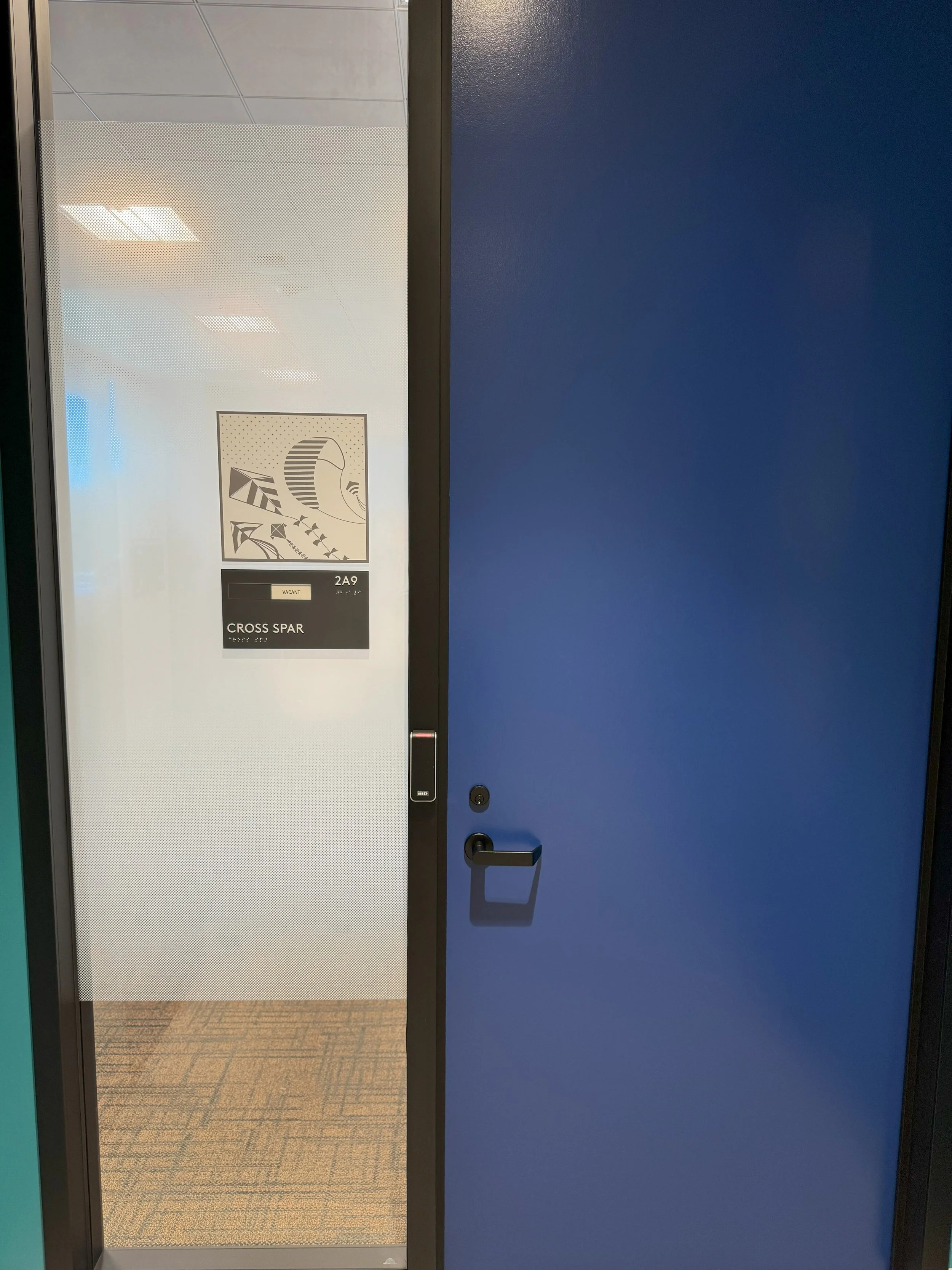 Room identification signage installed with environmental graphics to support intuitive office wayfinding.