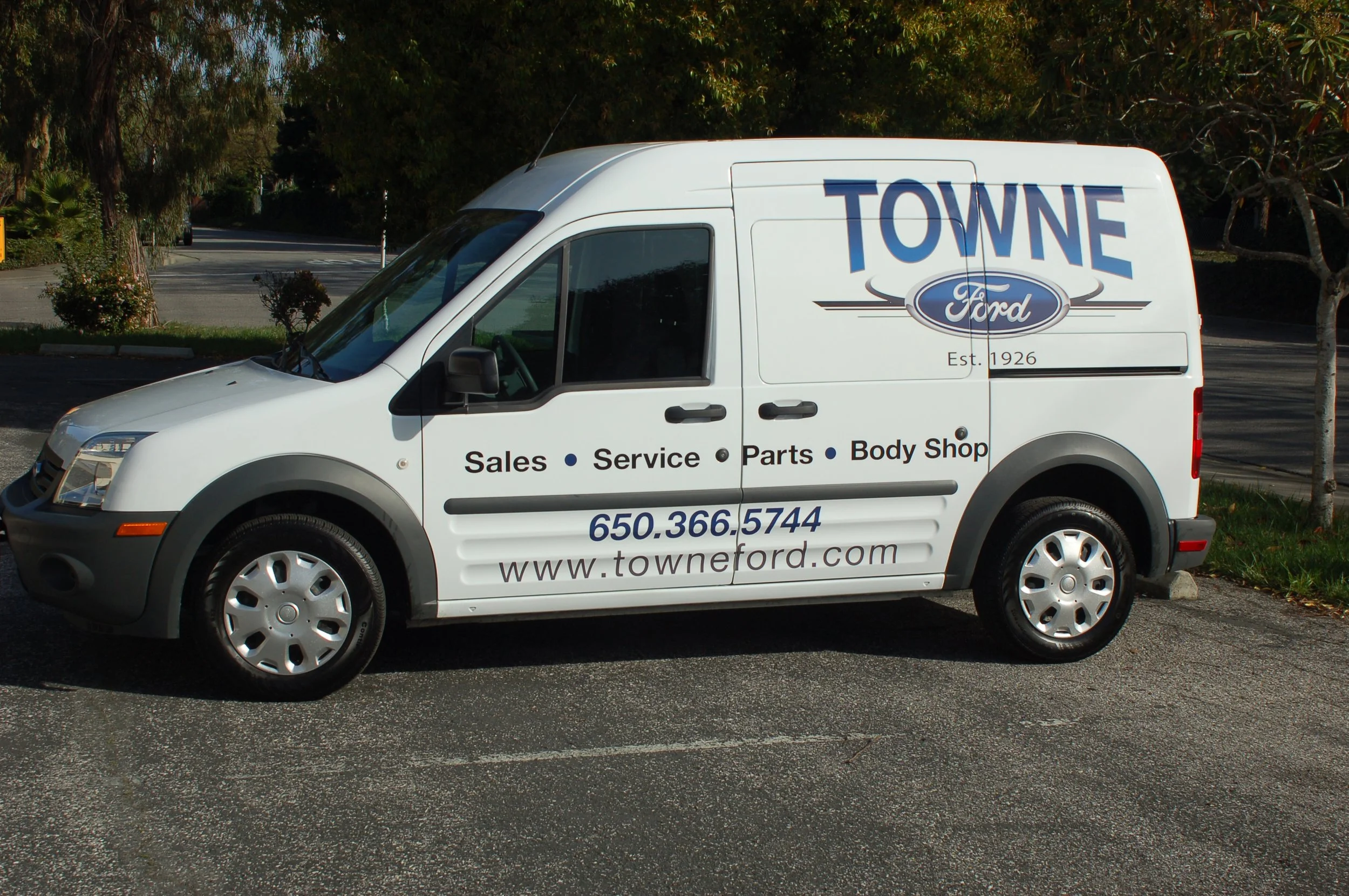 Service van with side panel graphics and vehicle branding for consistent fleet identity and professional appearance.