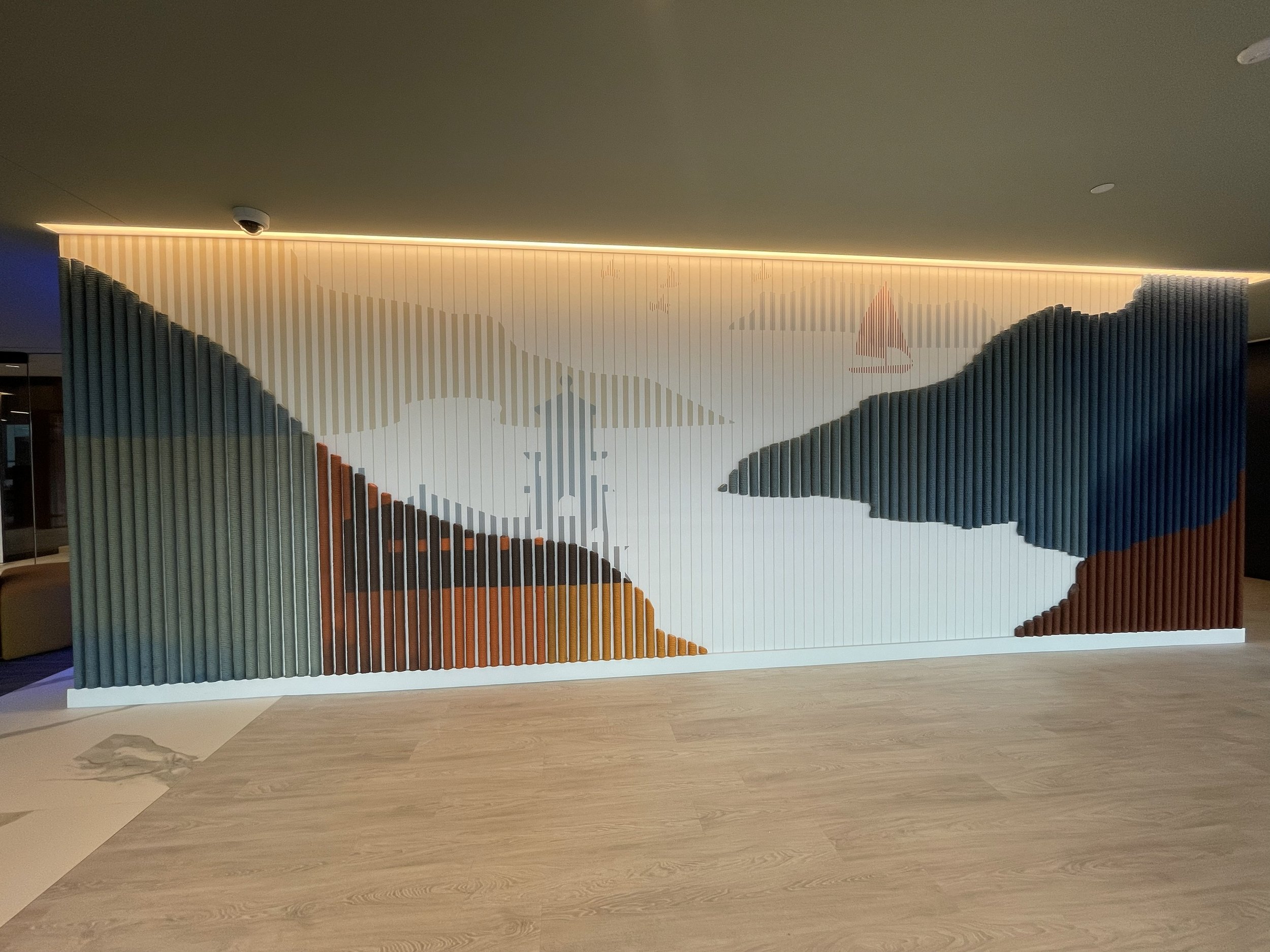 Large-scale environmental wallcovering with integrated dimensional rope elements creating a landscape-inspired feature wall at KPMG office in Minneapolis, Minnesota.