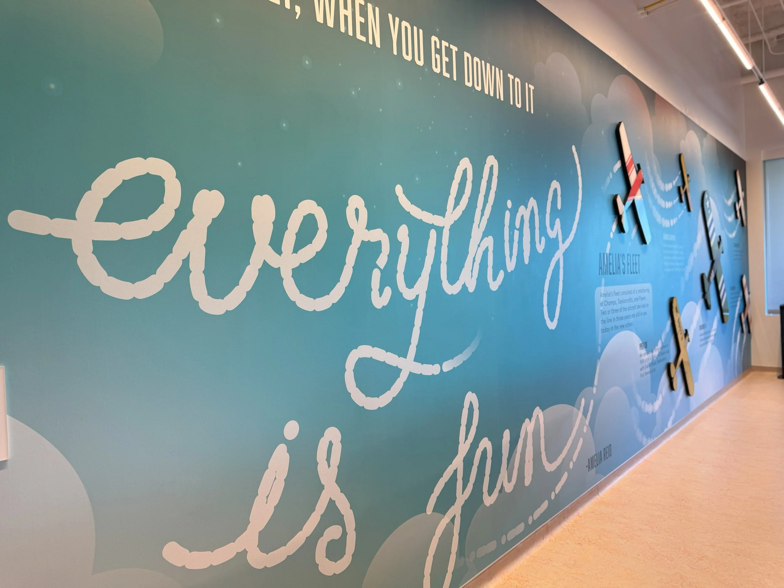 Inspirational environmental typography integrated into branded workplace wall graphics.