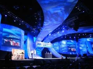 Large-scale custom stage and event display with immersive graphics and lighting for corporate conference presentation