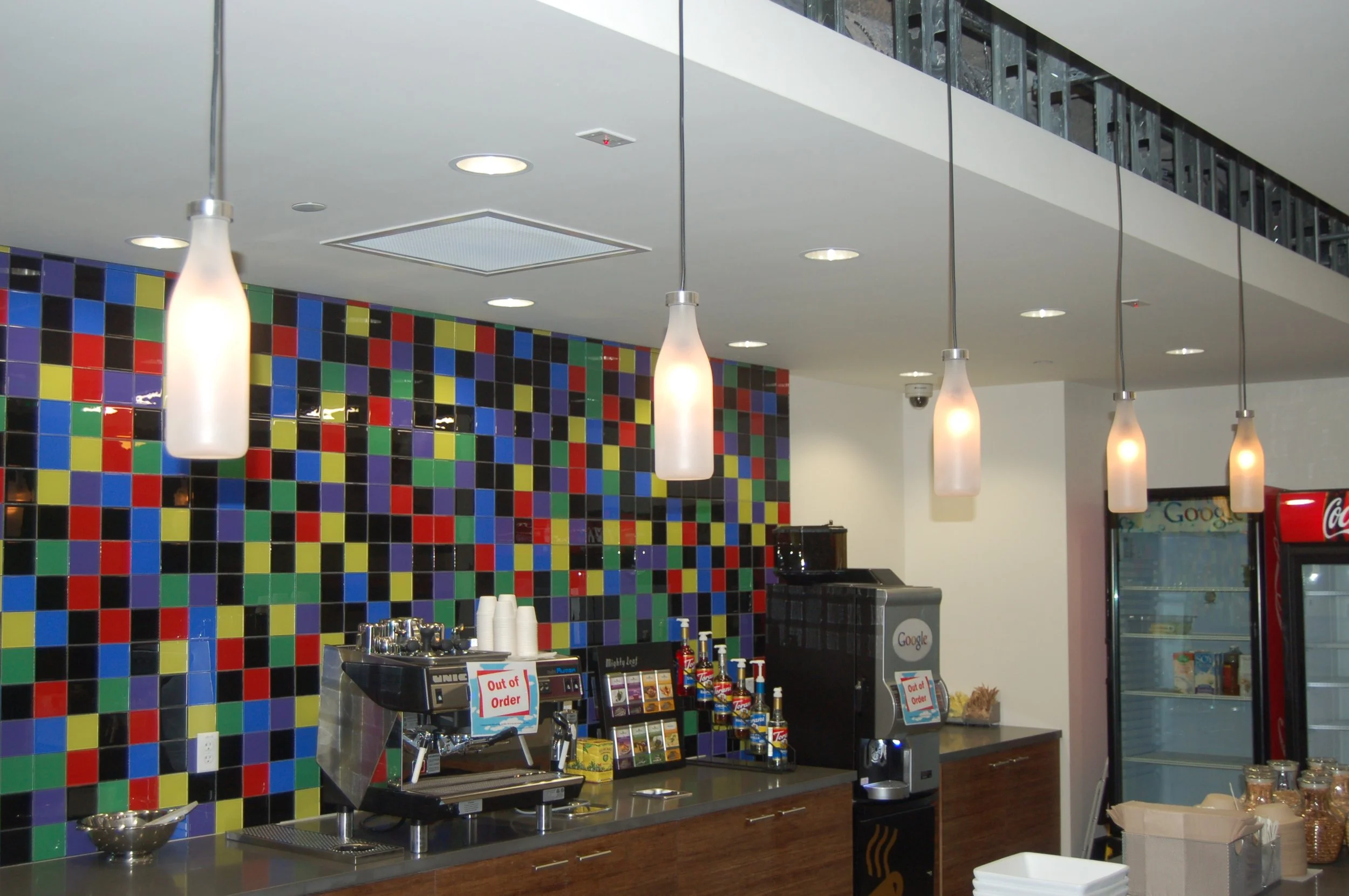 Colorful mosaic-style environmental graphic wall adding vibrant branding to a modern workspace.