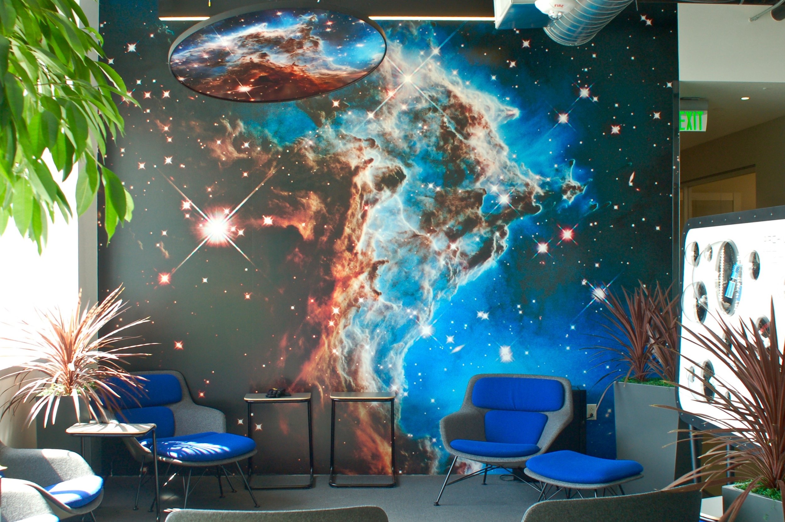Immersive galaxy-themed custom wallcovering transforming a collaborative workspace with large-format environmental graphics.
