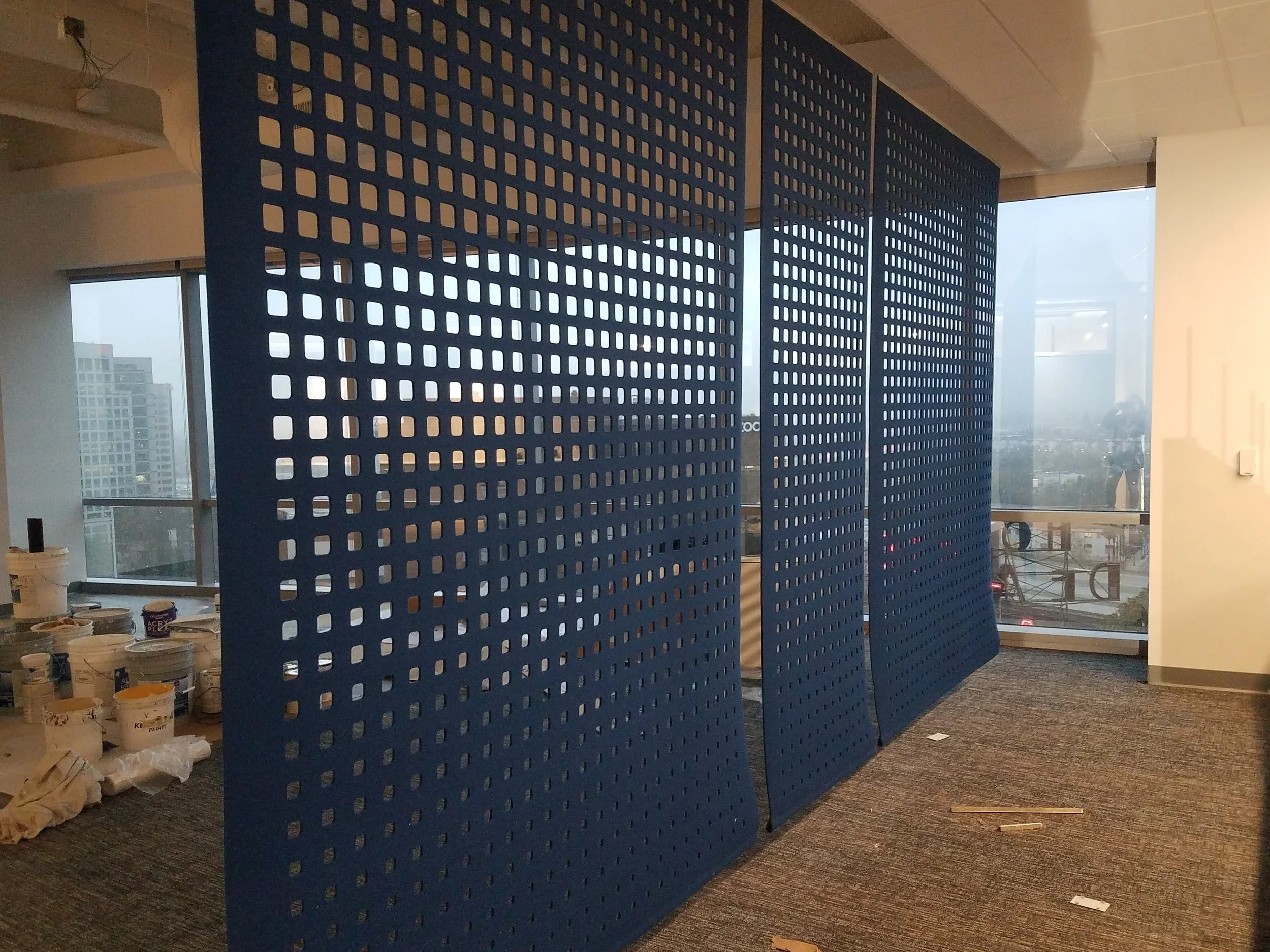 Perforated partition wall creating visual separation and acoustic control in office environment
