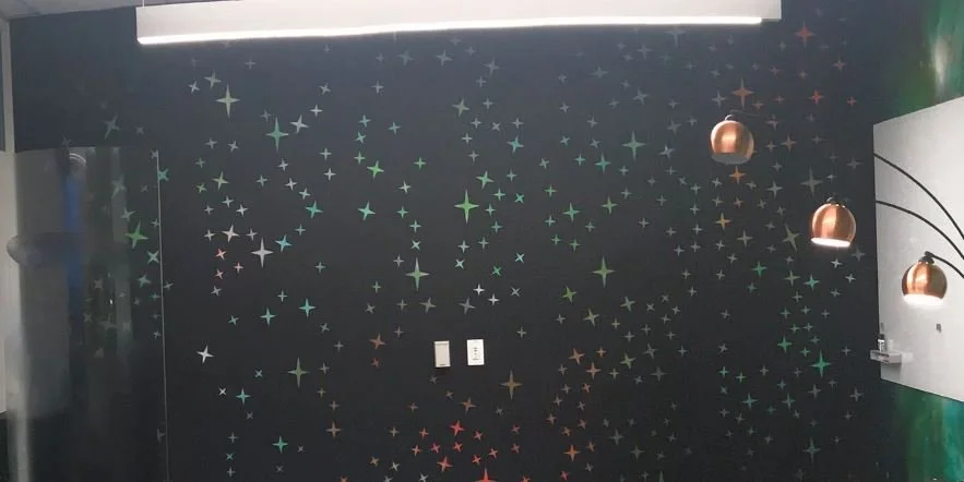 Custom printed acoustic wall combining environmental graphics with sound absorption