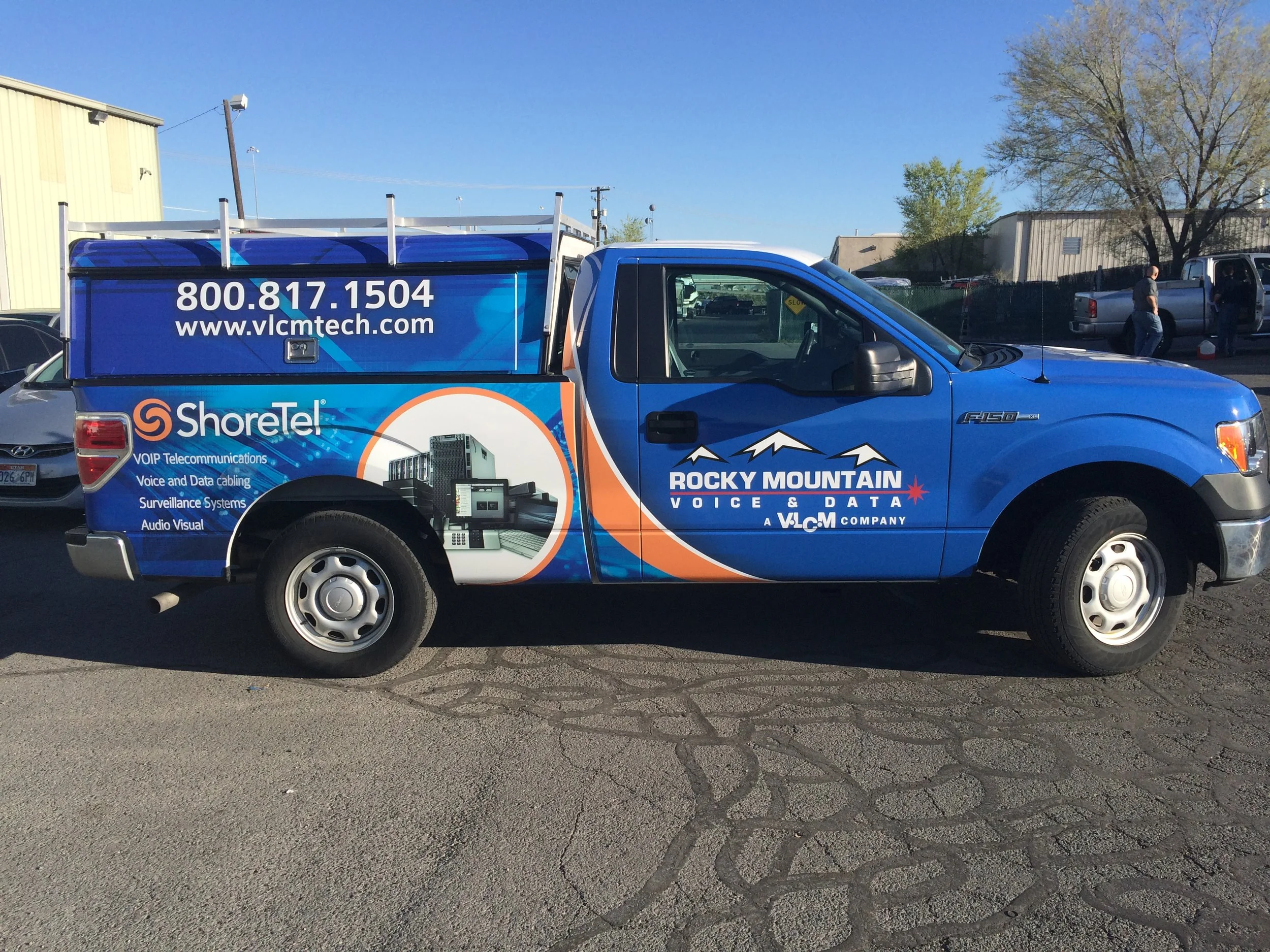 Side view commercial service truck with partial wrap and company branding for field operations visibility.