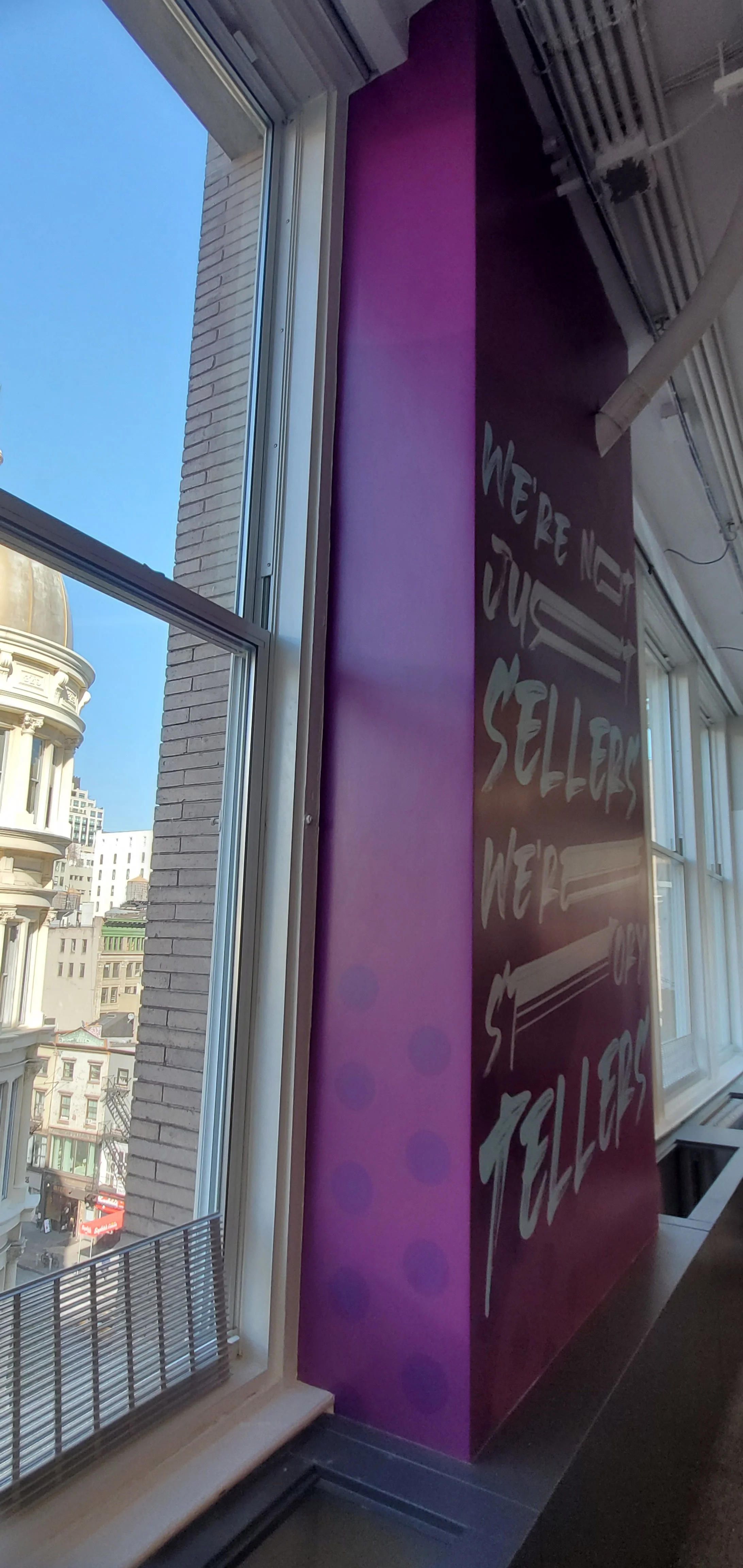 Side view of installed vertical environmental graphic at eBay New York office showing branded workplace messaging on window-adjacent feature wall