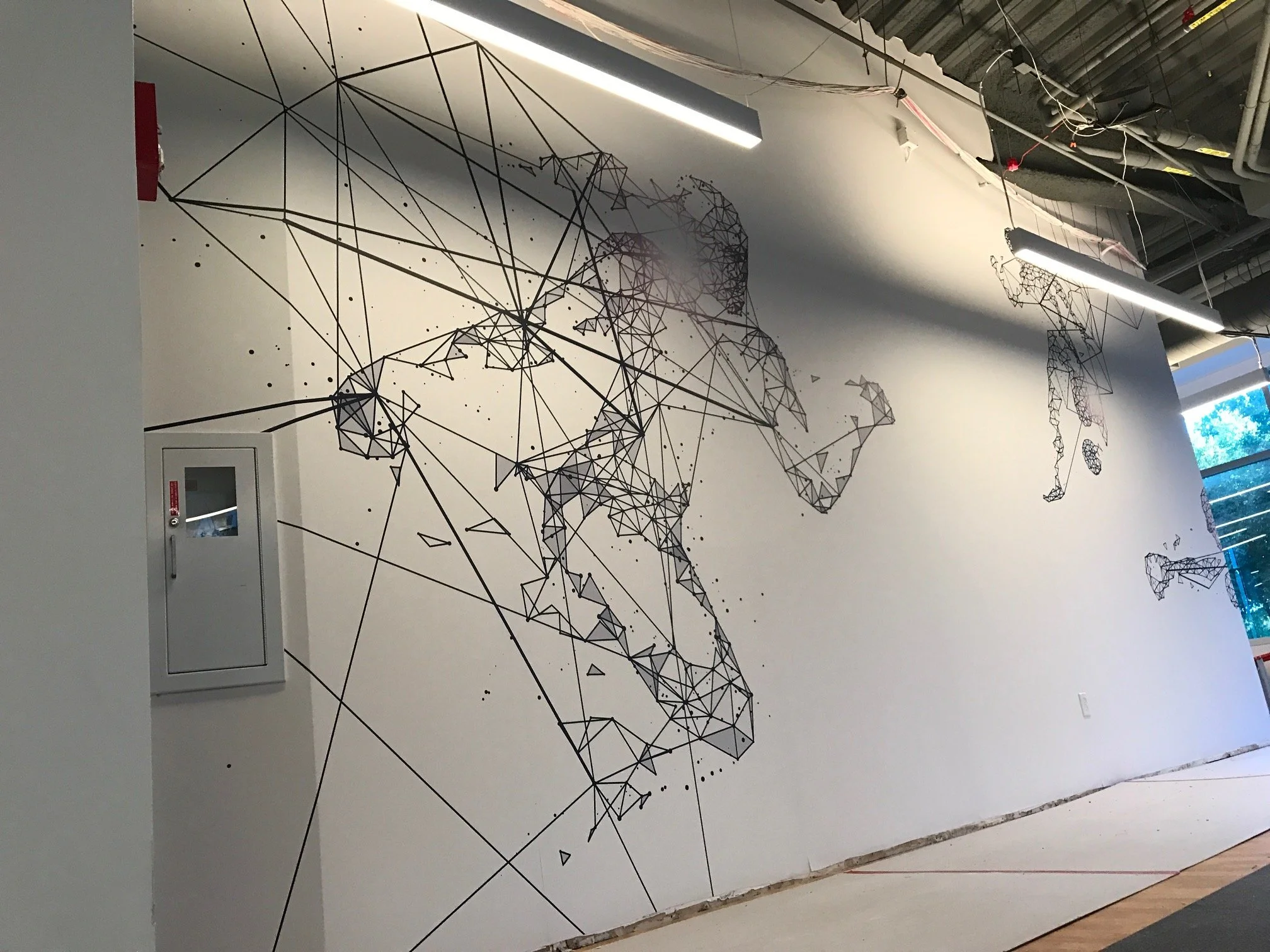 Minimalist dot and line pattern wallcovering adding subtle texture and movement to a modern office environment.