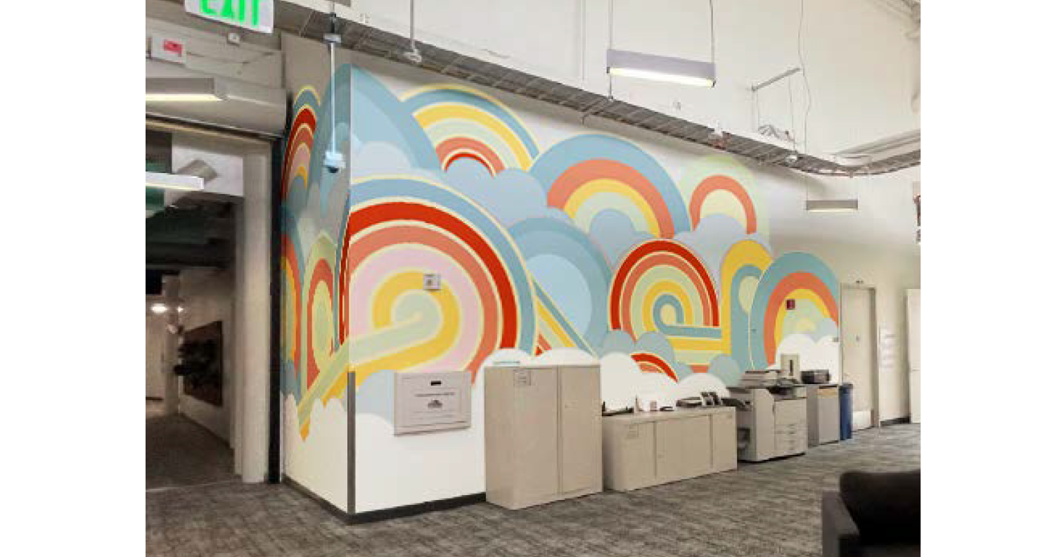In-progress installation of large-scale environmental graphics wrapping staircase and adjacent wall in a modern office interior