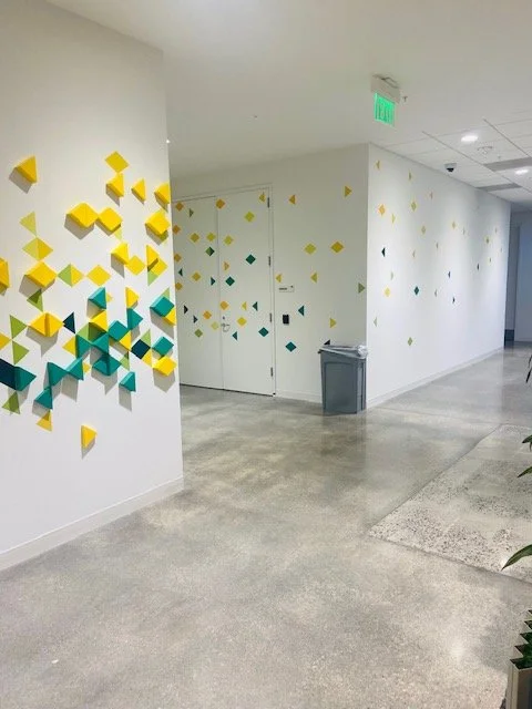 Custom wall graphic installation using modular elements to build a dynamic visual pattern within commercial interior space.