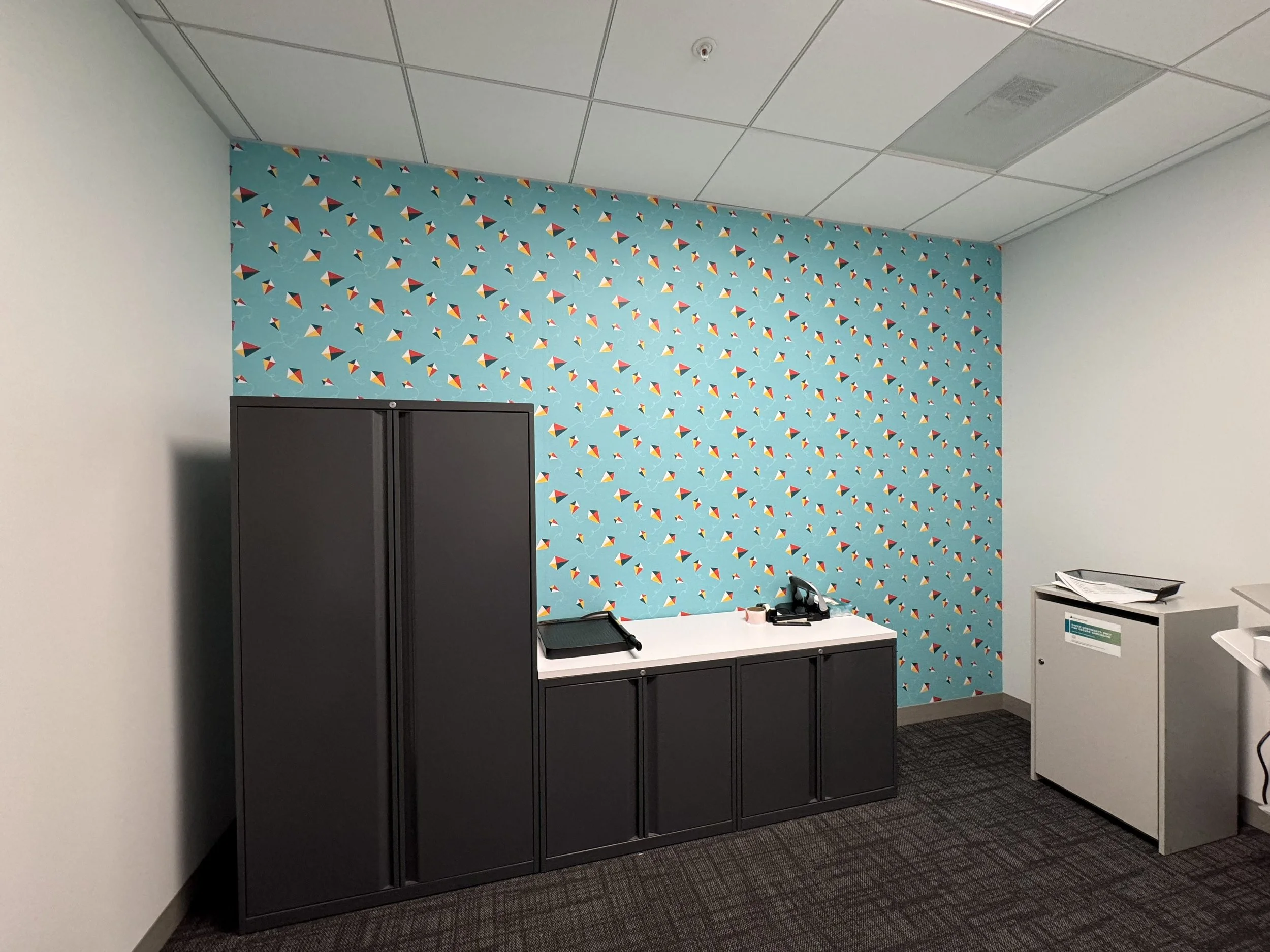 Print room featuring patterned environmental wall graphics that reinforce brand identity 