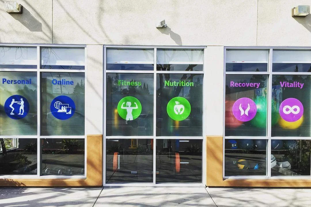 Commercial storefront windows featuring branded privacy window film graphics