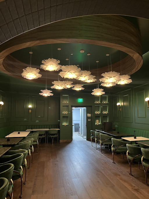 Custom circular wood ceiling feature with horizontal veneer grain and suspended decorative lighting, creating a warm architectural focal point in a commercial hospitality interior.