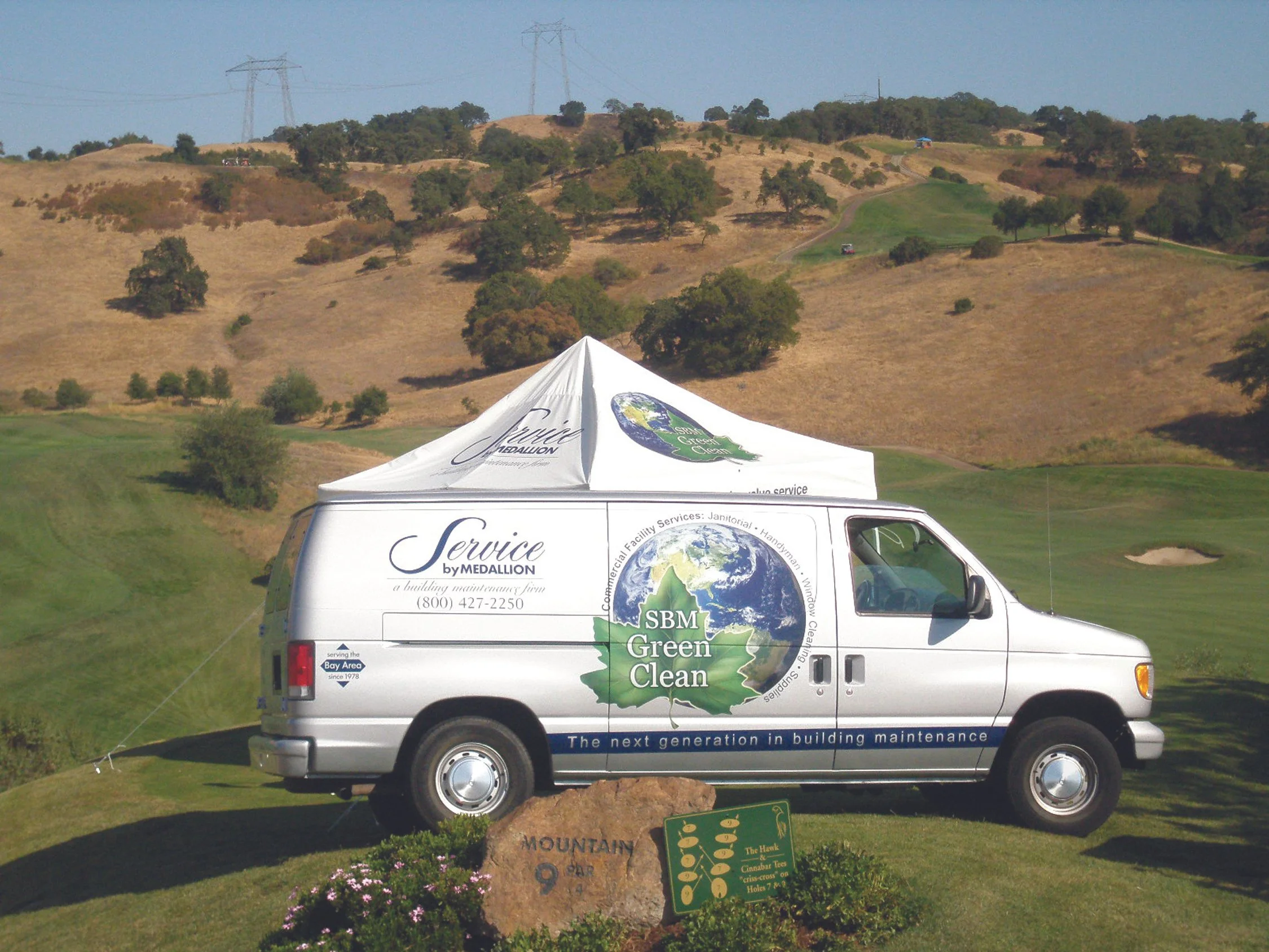 White service van with full vehicle wrap showcasing environmental company branding and messaging.
