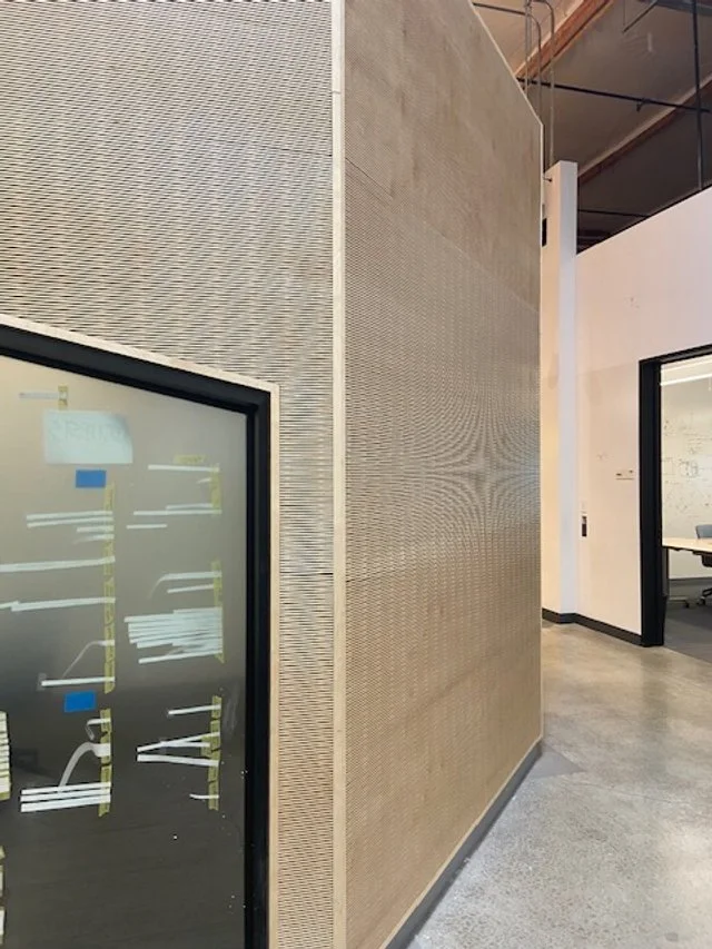 Contemporary office hallway with architectural wood wall cladding and glass conference rooms