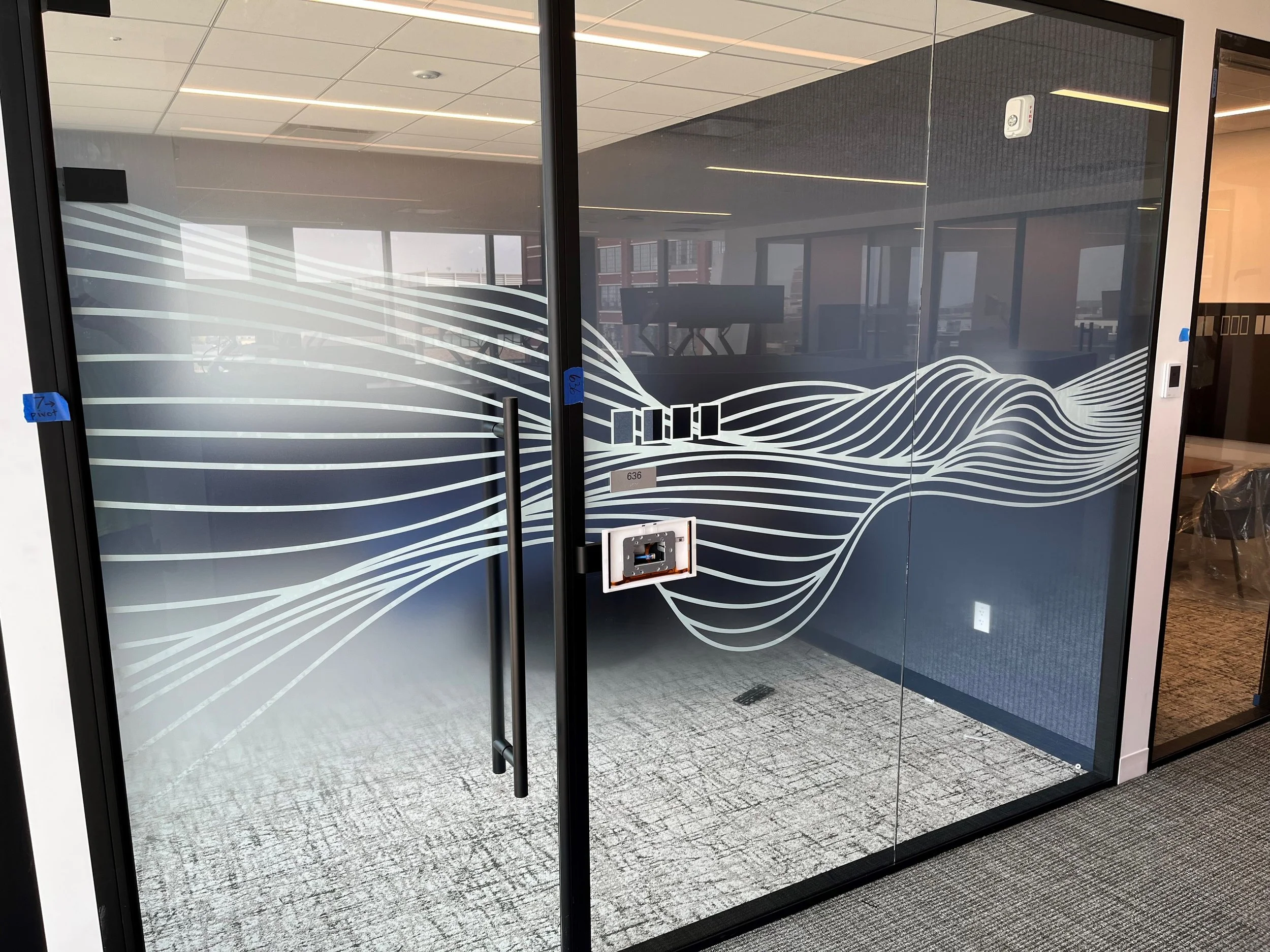 Close-up detail of custom wave-pattern privacy window film applied to glass office door and partition at KPMG in Minneapolis, Minnesota.