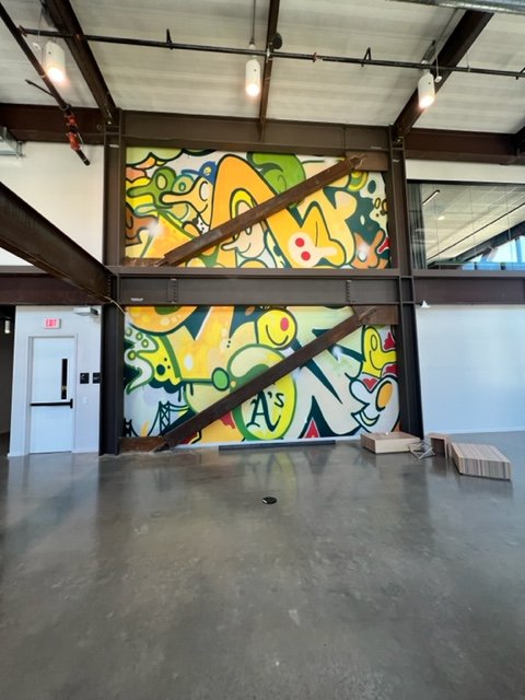 Commercial office lounge featuring large-format custom wall mural and environmental graphics installation in a collaborative workspace