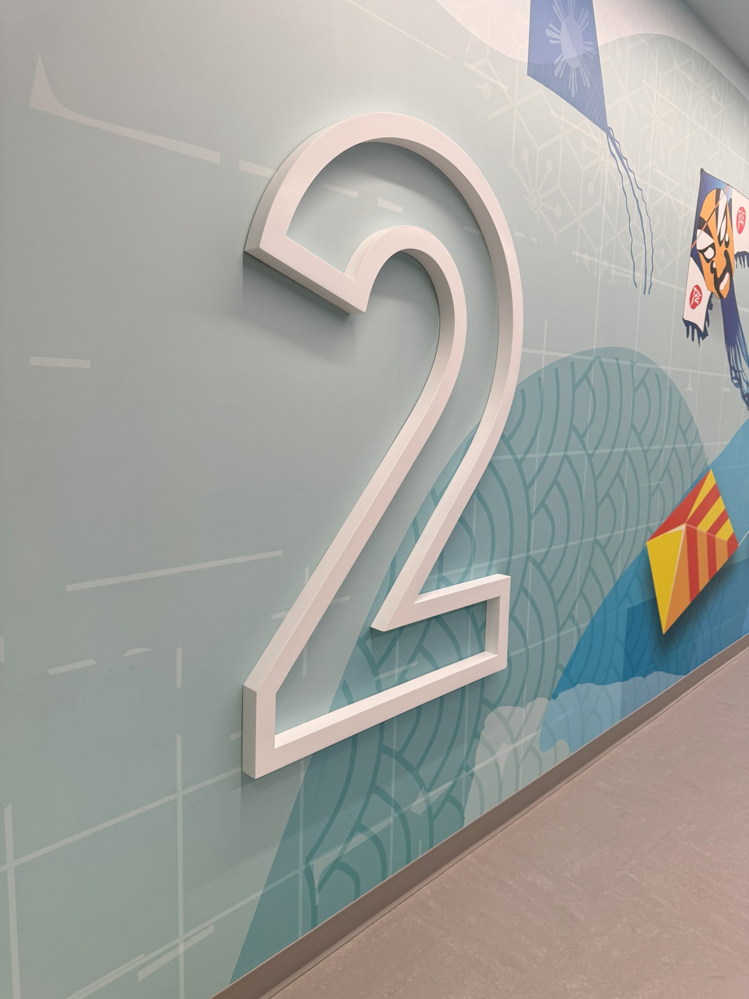 Dimensional floor identification signage combined with environmental graphics for clear level wayfinding.