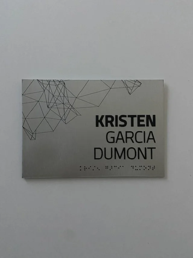 Custom office nameplate signage for employee and room identification in corporate environment