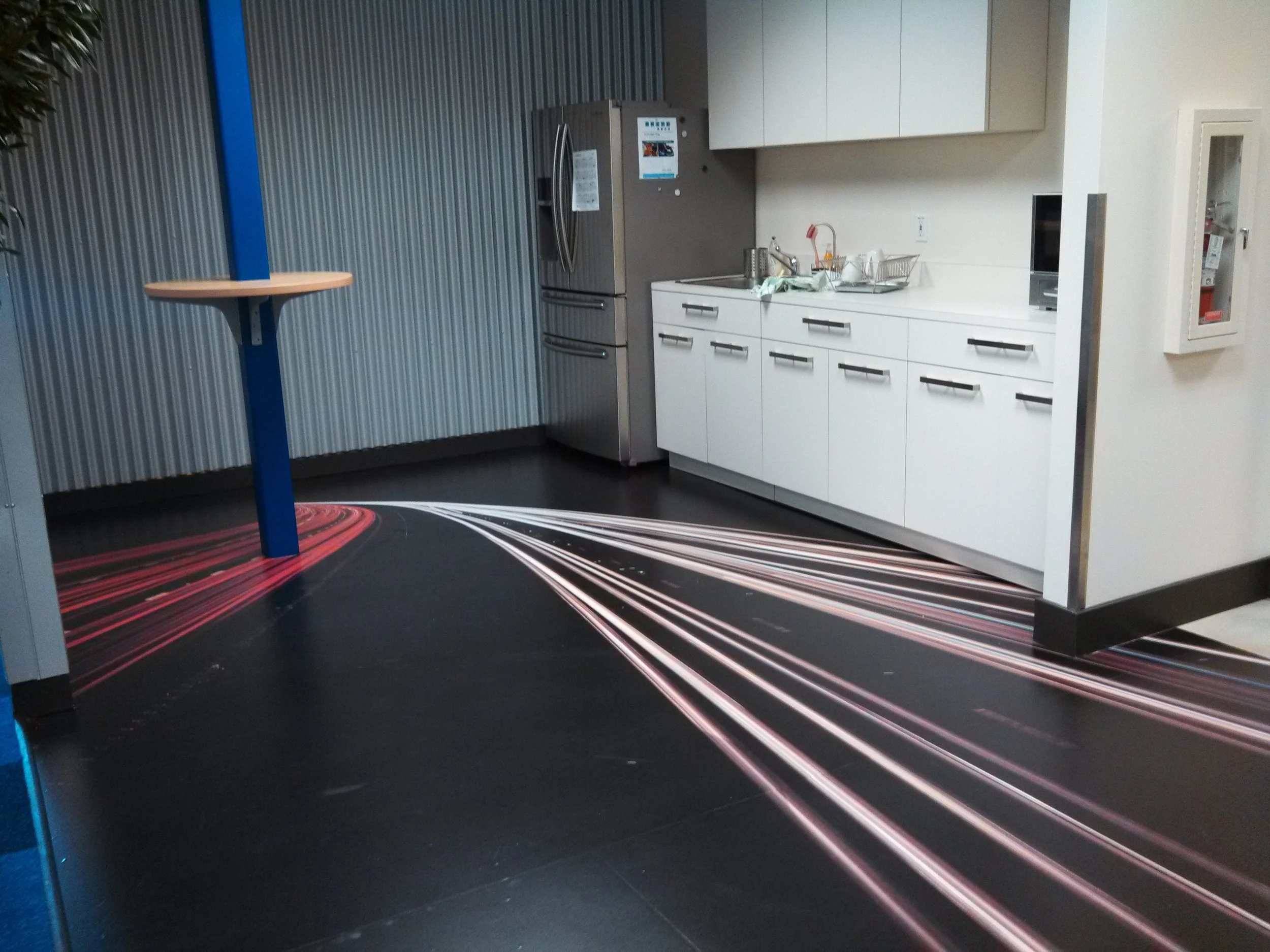Custom floor graphics with directional light-style pattern creating a dynamic branded feature in commercial space