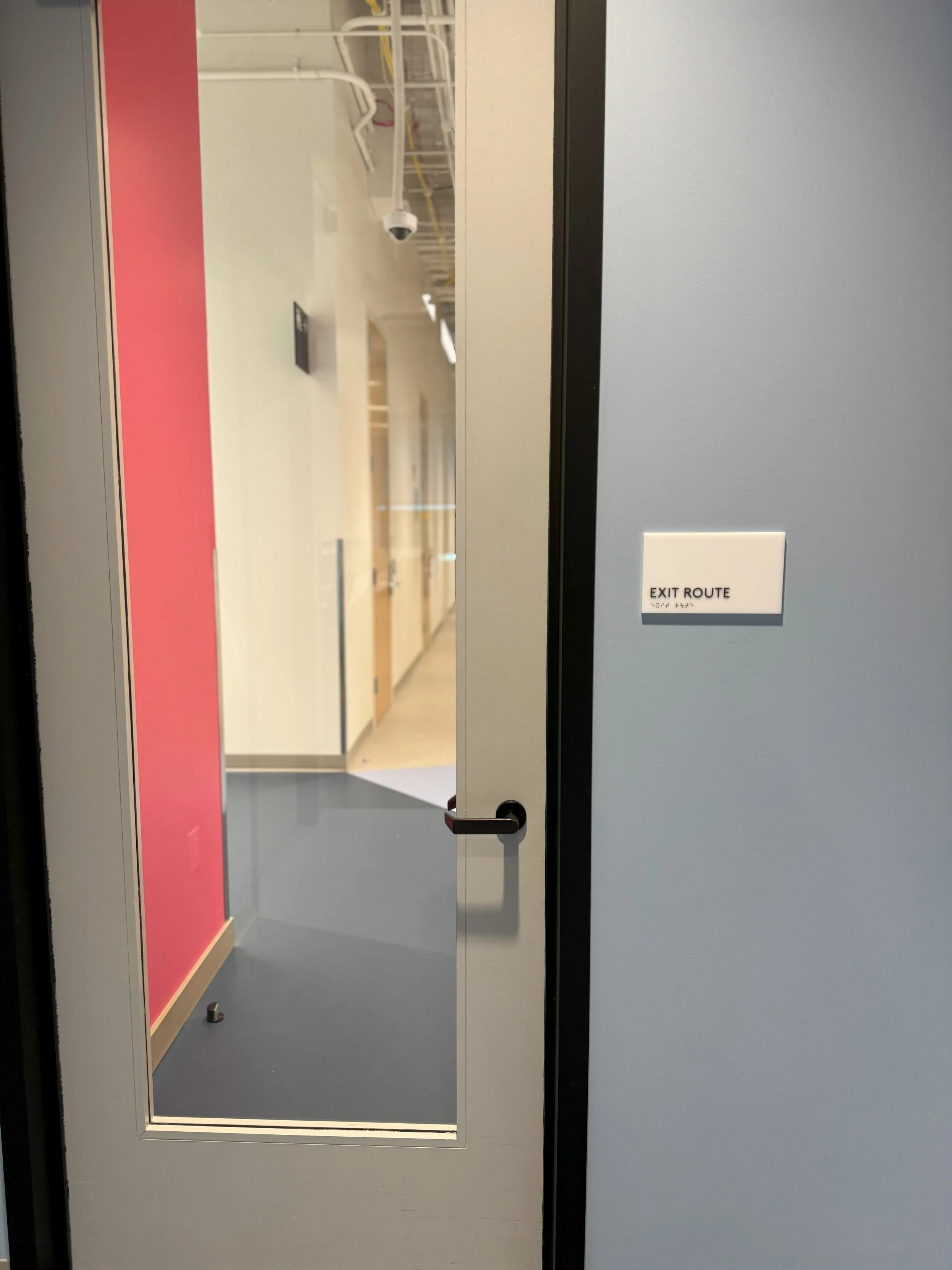 Door identification signage with color-coded wall accents to support intuitive workplace wayfinding.