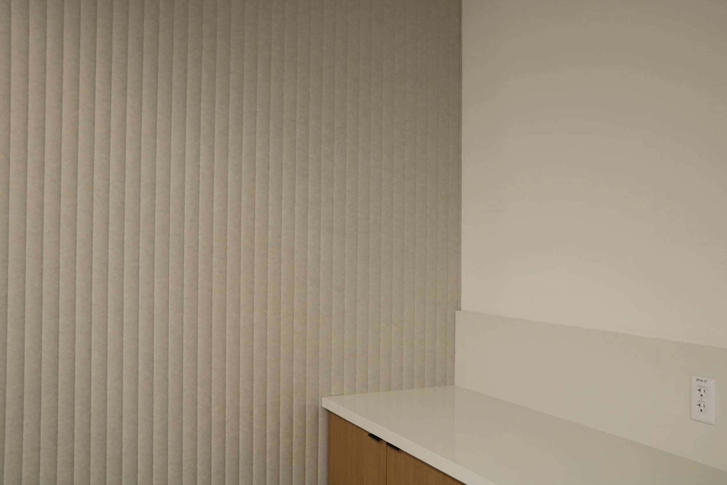 Vertical acoustic felt wall panels installed in commercial interior workspace to improve sound absorption and reduce noise.