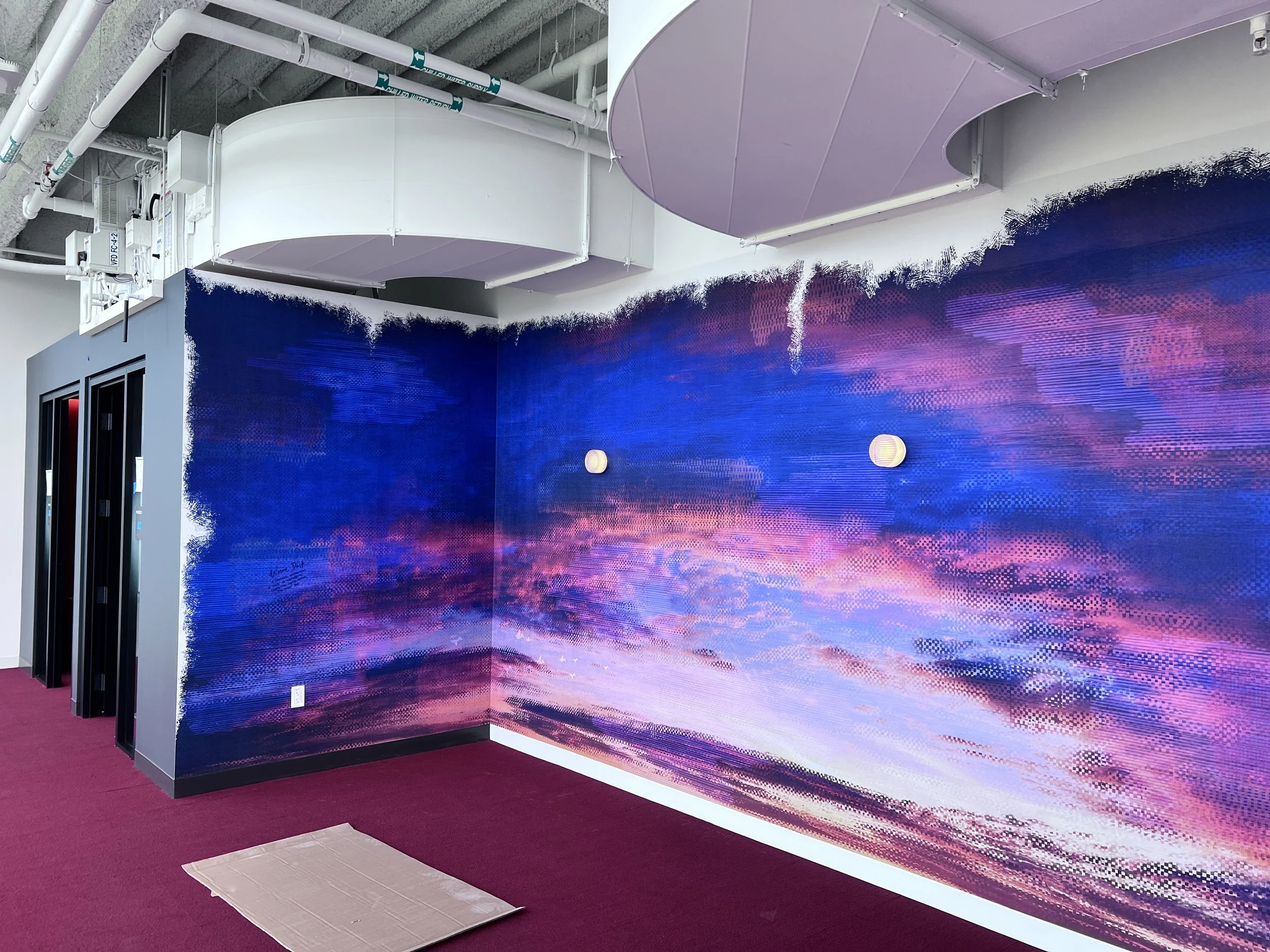 Galaxy-inspired immersive wall mural creating a dramatic feature wall in a commercial interior.