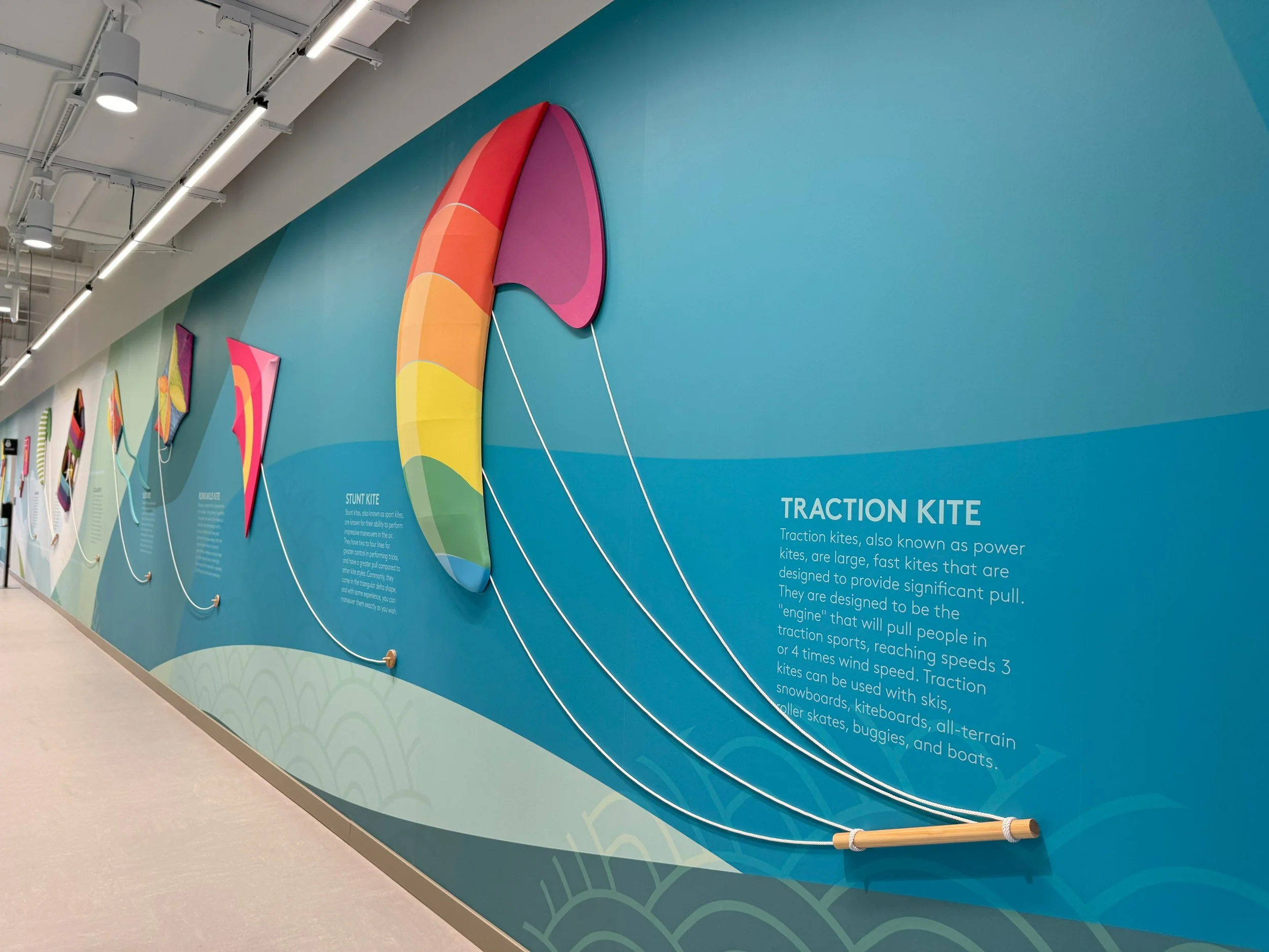Full-wall environmental mural with vibrant graphic elements creating a dynamic and engaging office corridor experience.