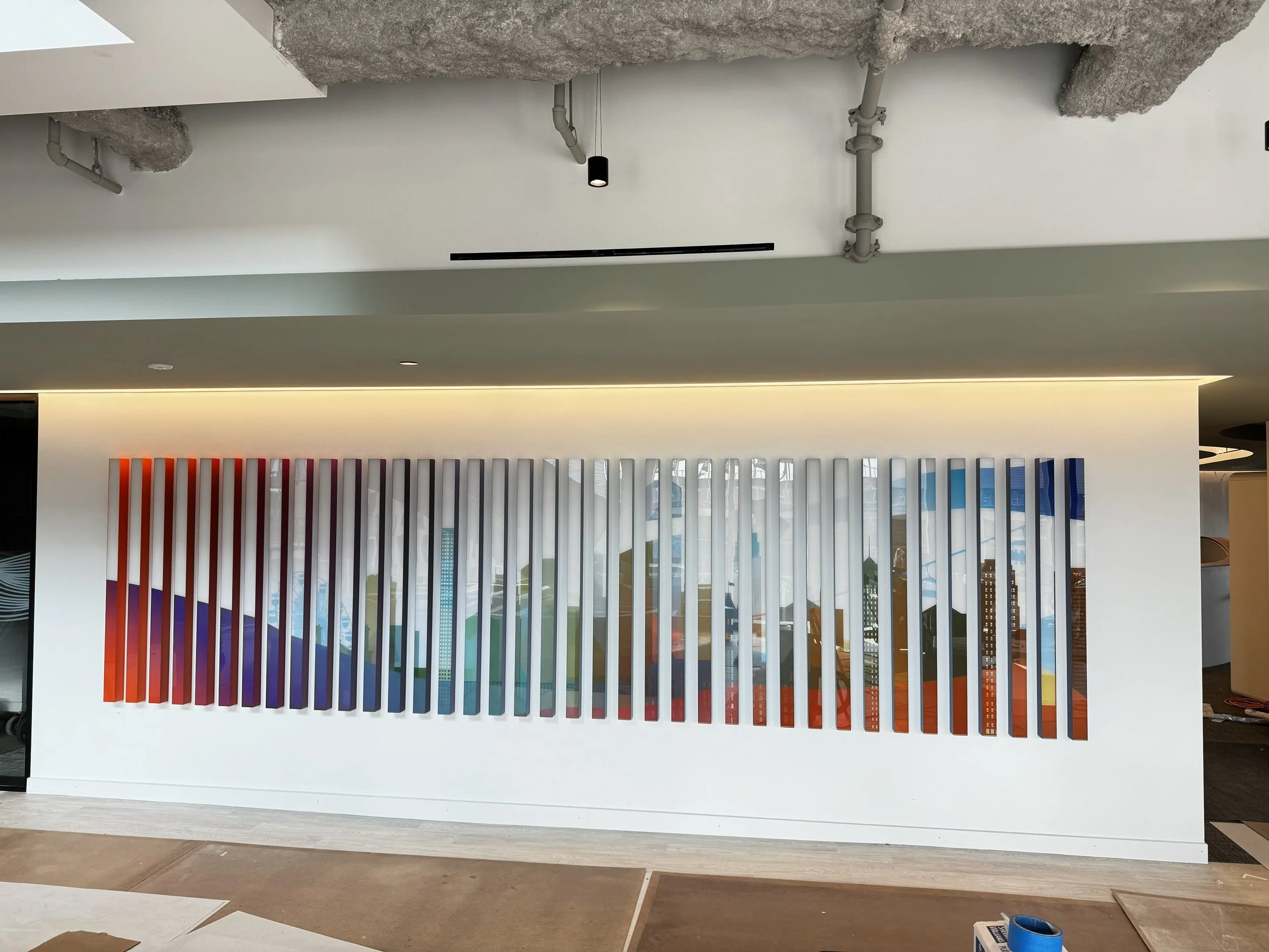Completed installation of large-scale dimensional feature wall with gradient acrylic panels mounted on MDF backing in the KPMG reception area in Minneapolis, Minnesota.