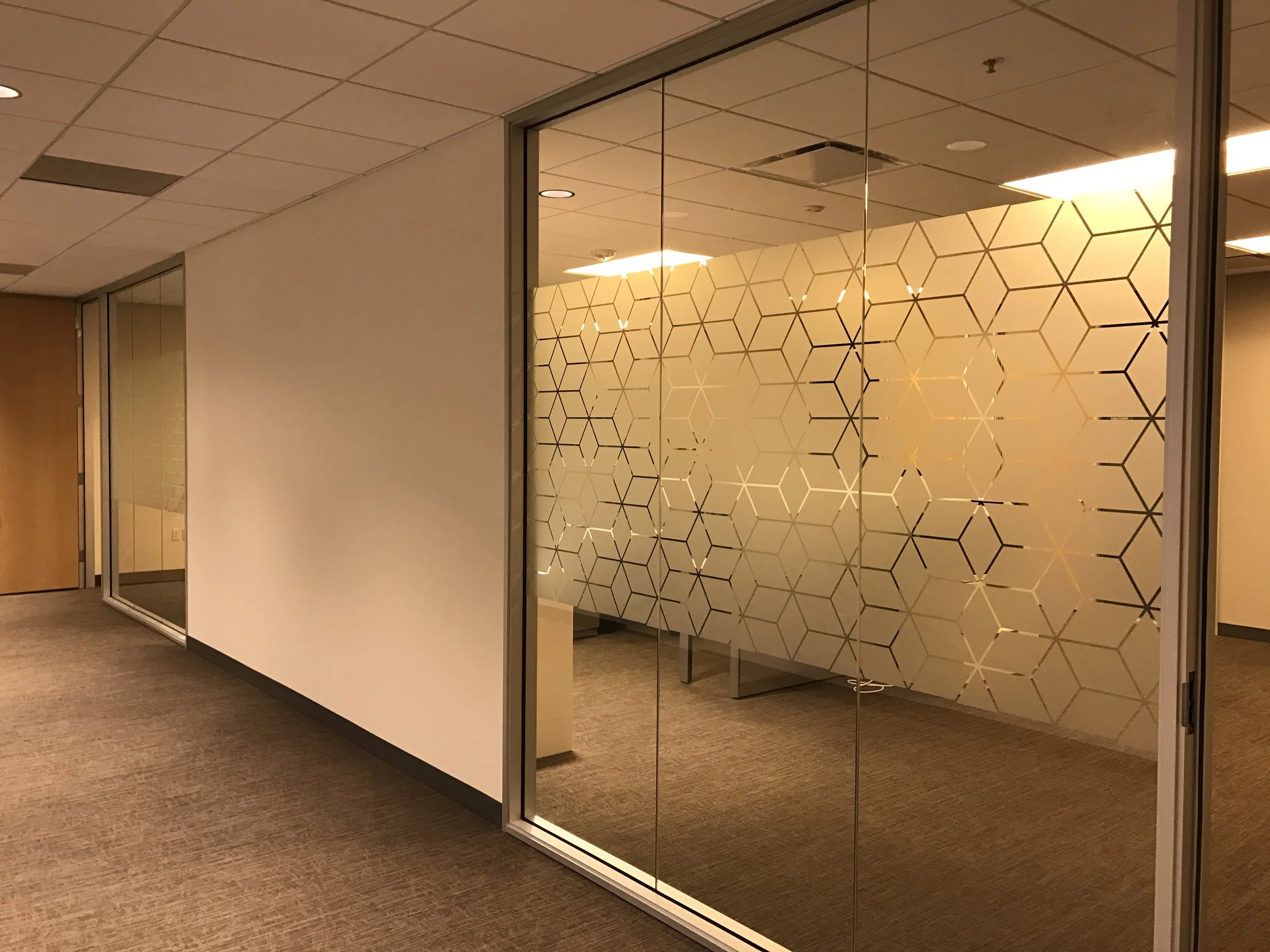 Custom geometric gradient window film installed on conference room glass for subtle privacy