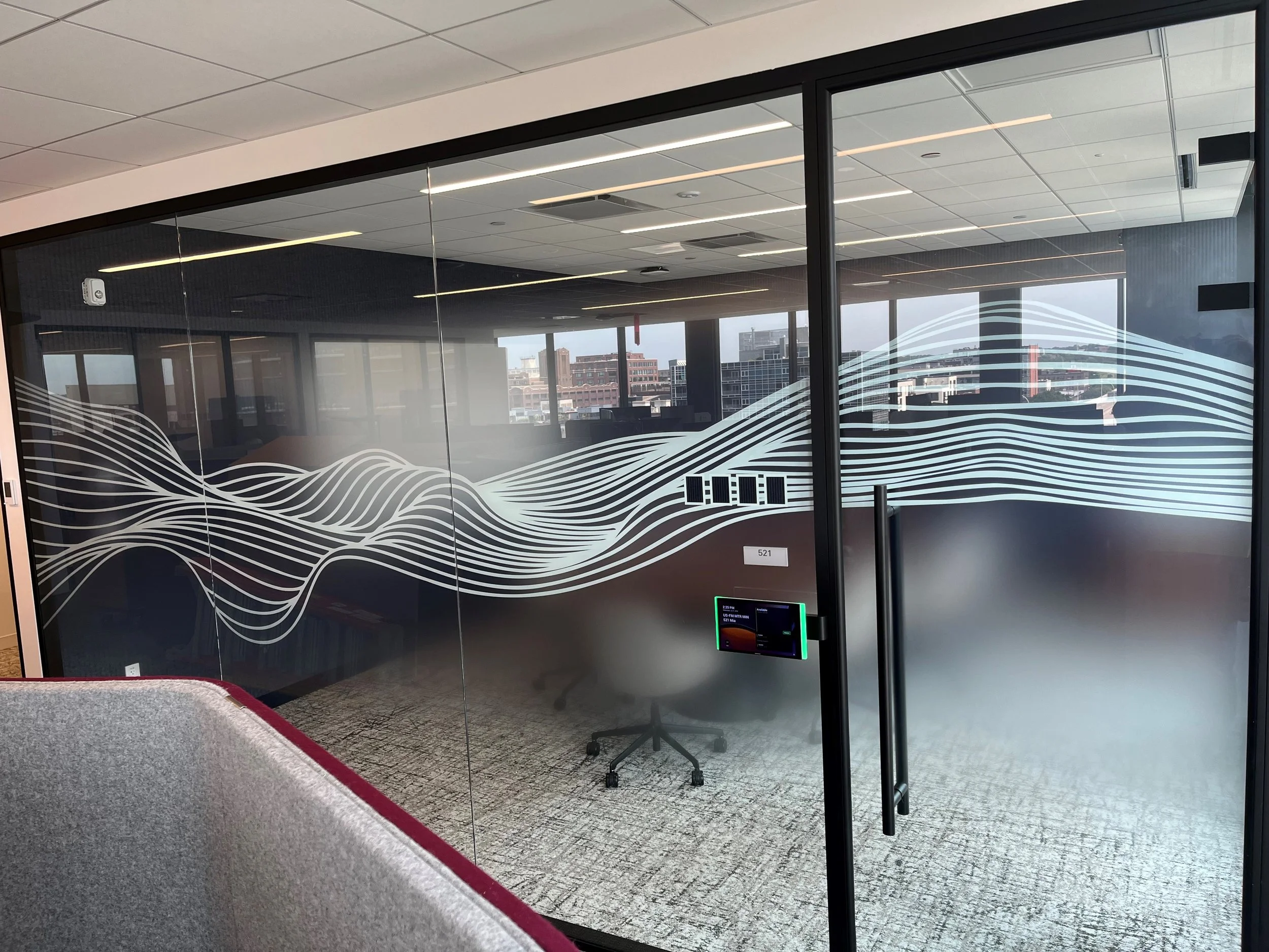 Decorative privacy window film with custom wave pattern installed on glass conference room at KPMG office in Minneapolis, Minnesota.